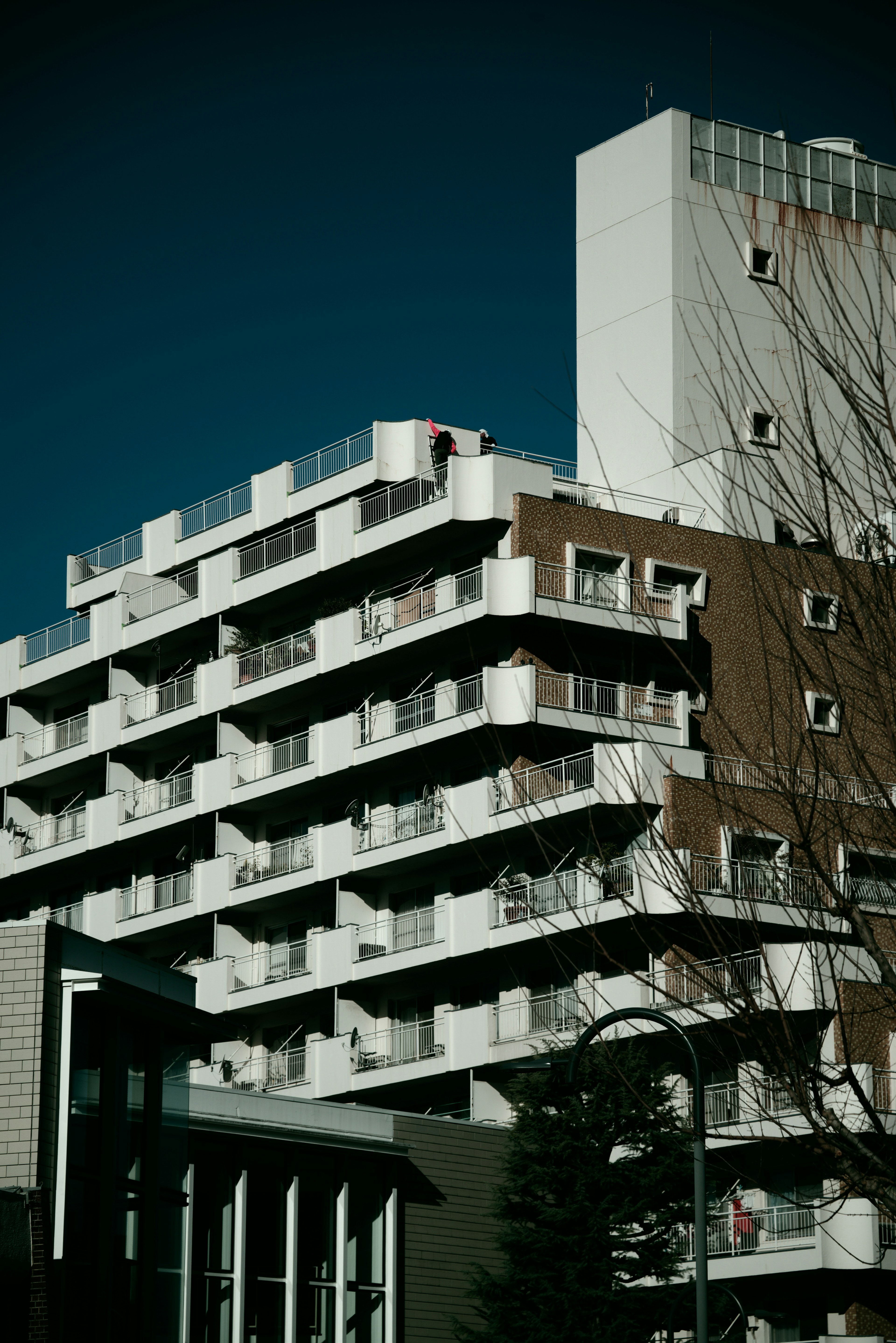 Modern apartment building with white balconies against a blue sky