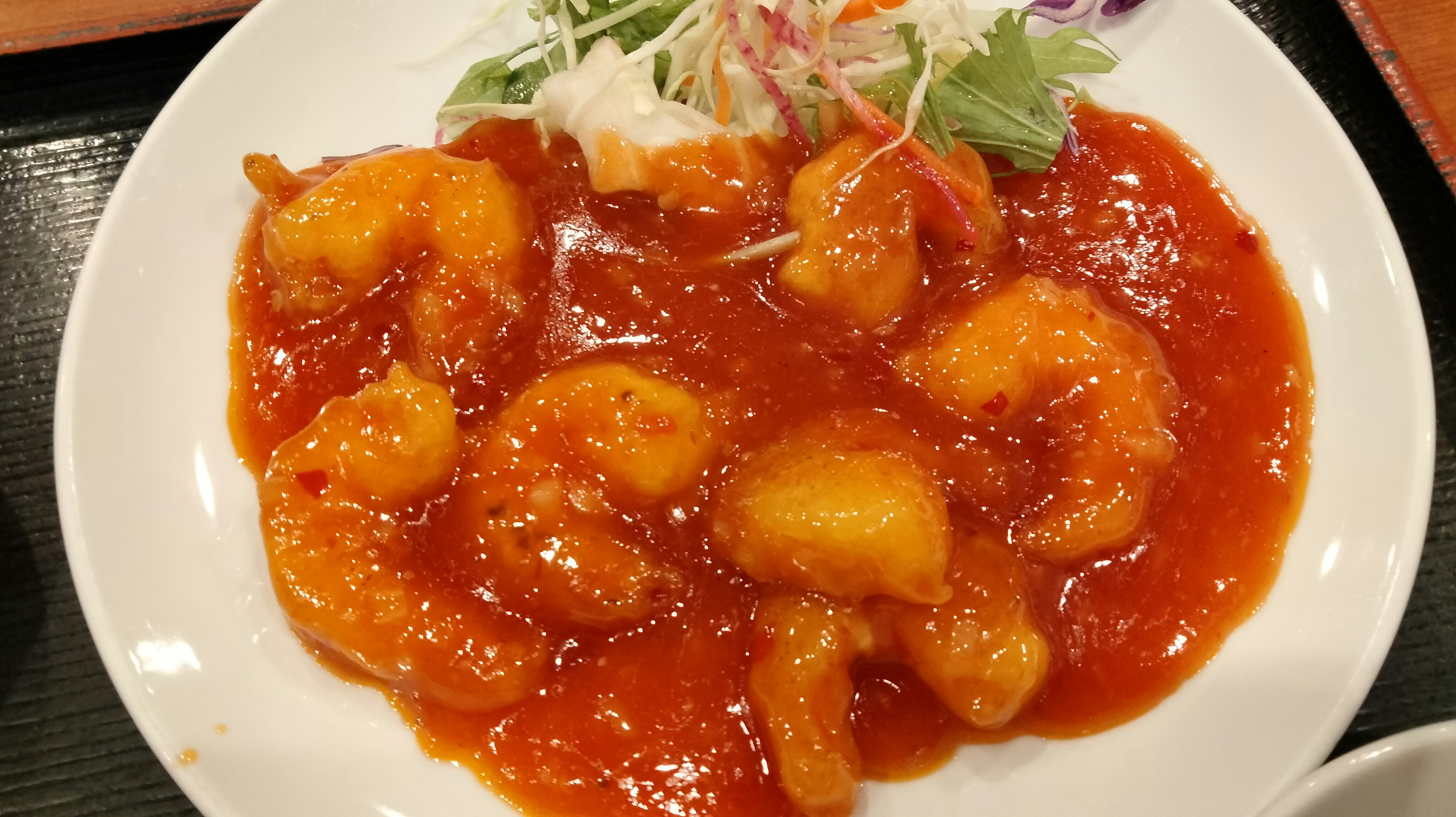 Shrimp dish in sweet and sour sauce with salad