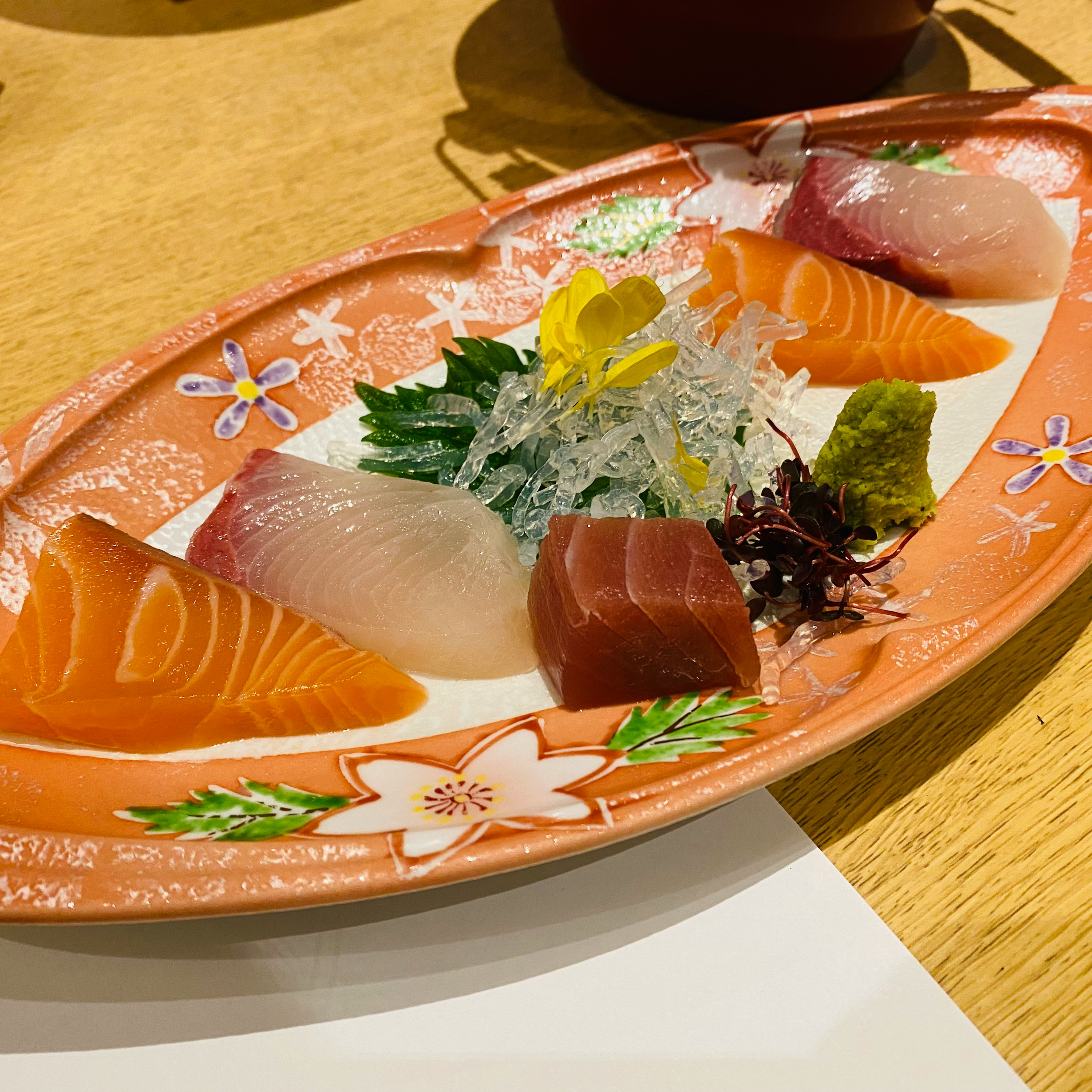 Plateau de sashimi vibrant présenté sur une assiette décorative orange