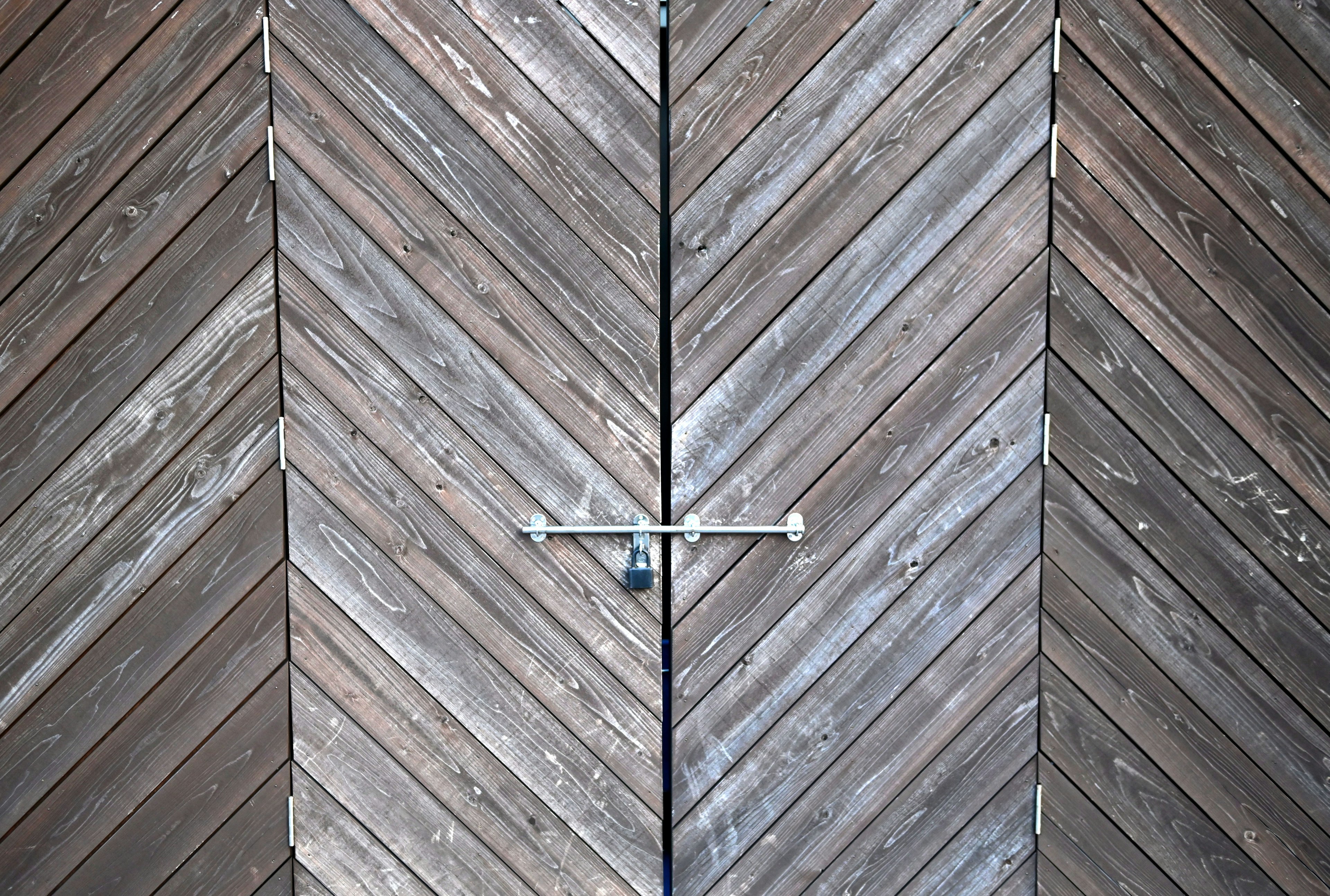 Wooden door featuring a chevron pattern with a lock