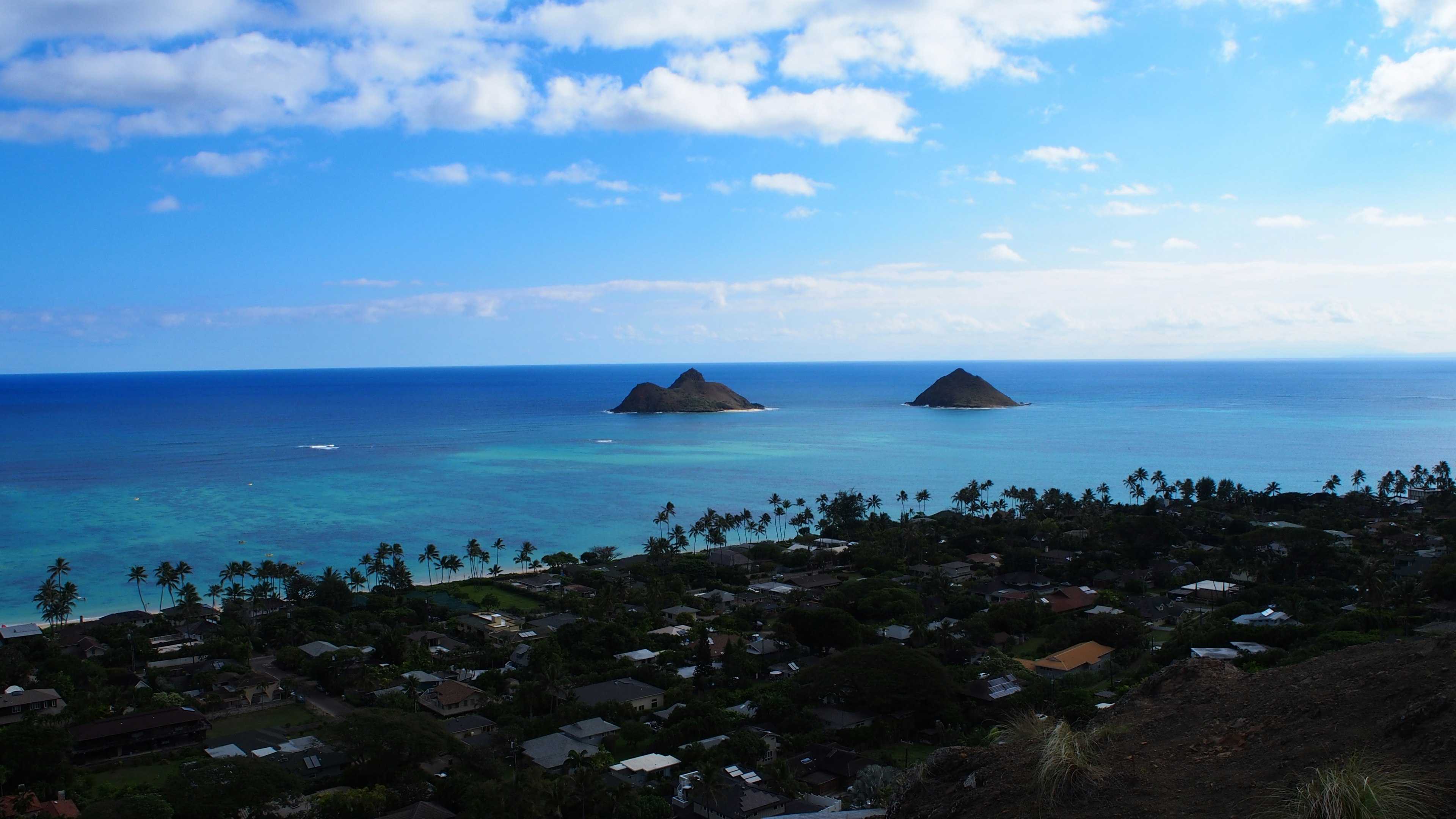 Pemandangan indah dua pulau kecil di lautan biru dengan kota pesisir di Hawaii