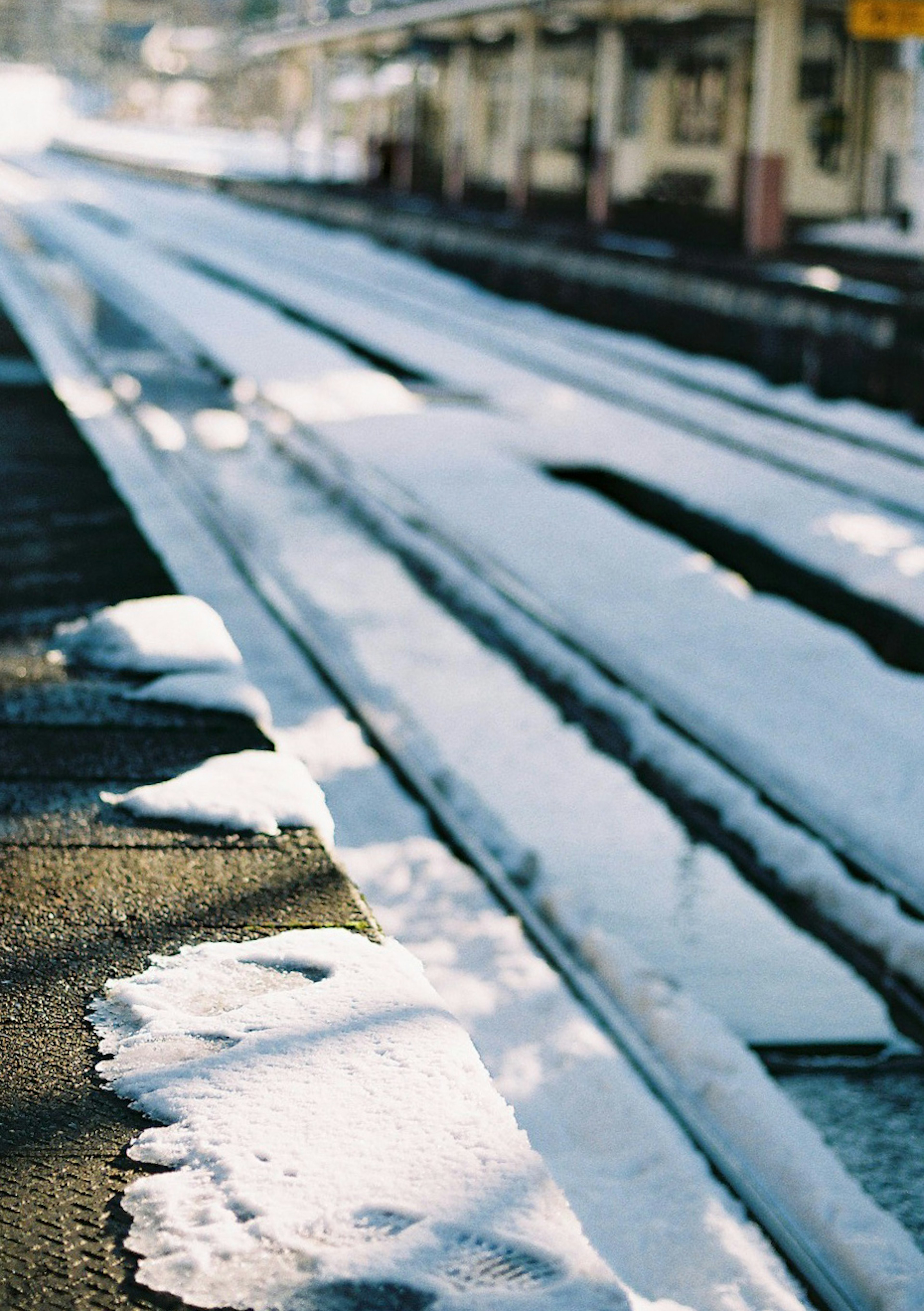 雪に覆われた鉄道の線路と駅の風景