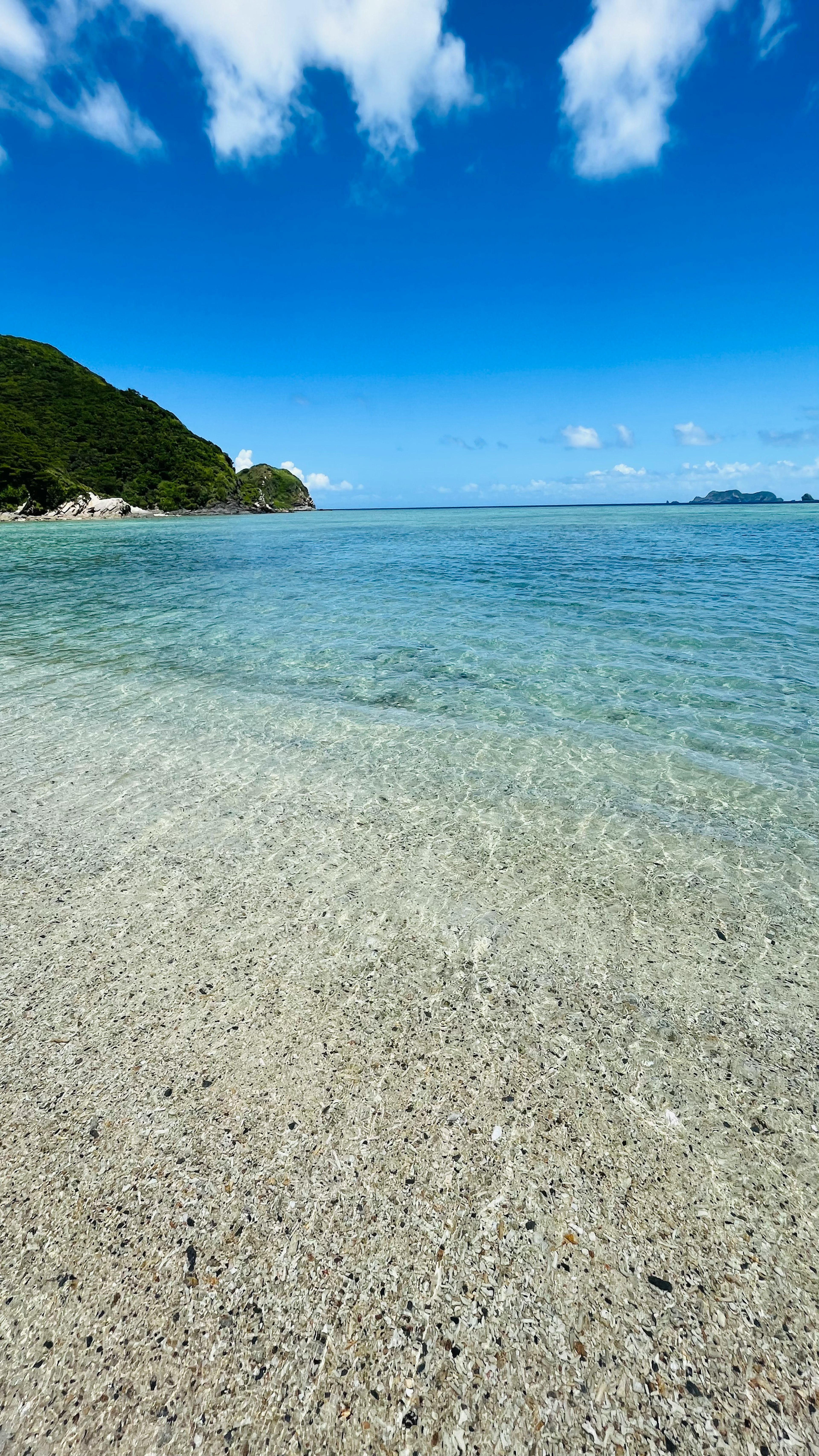 Acqua turchese chiara con spiaggia di sabbia e cielo blu