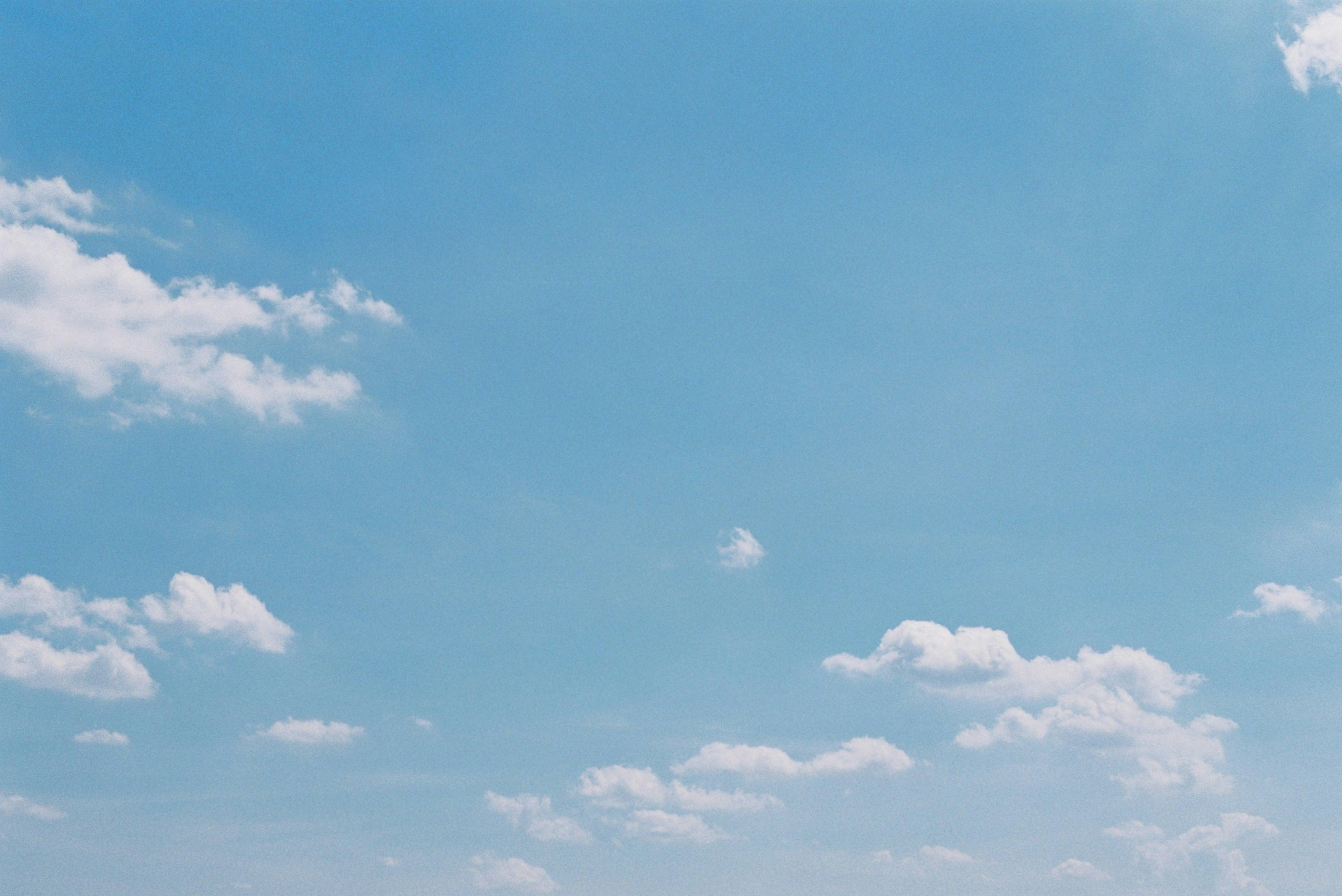 Clear blue sky with fluffy white clouds