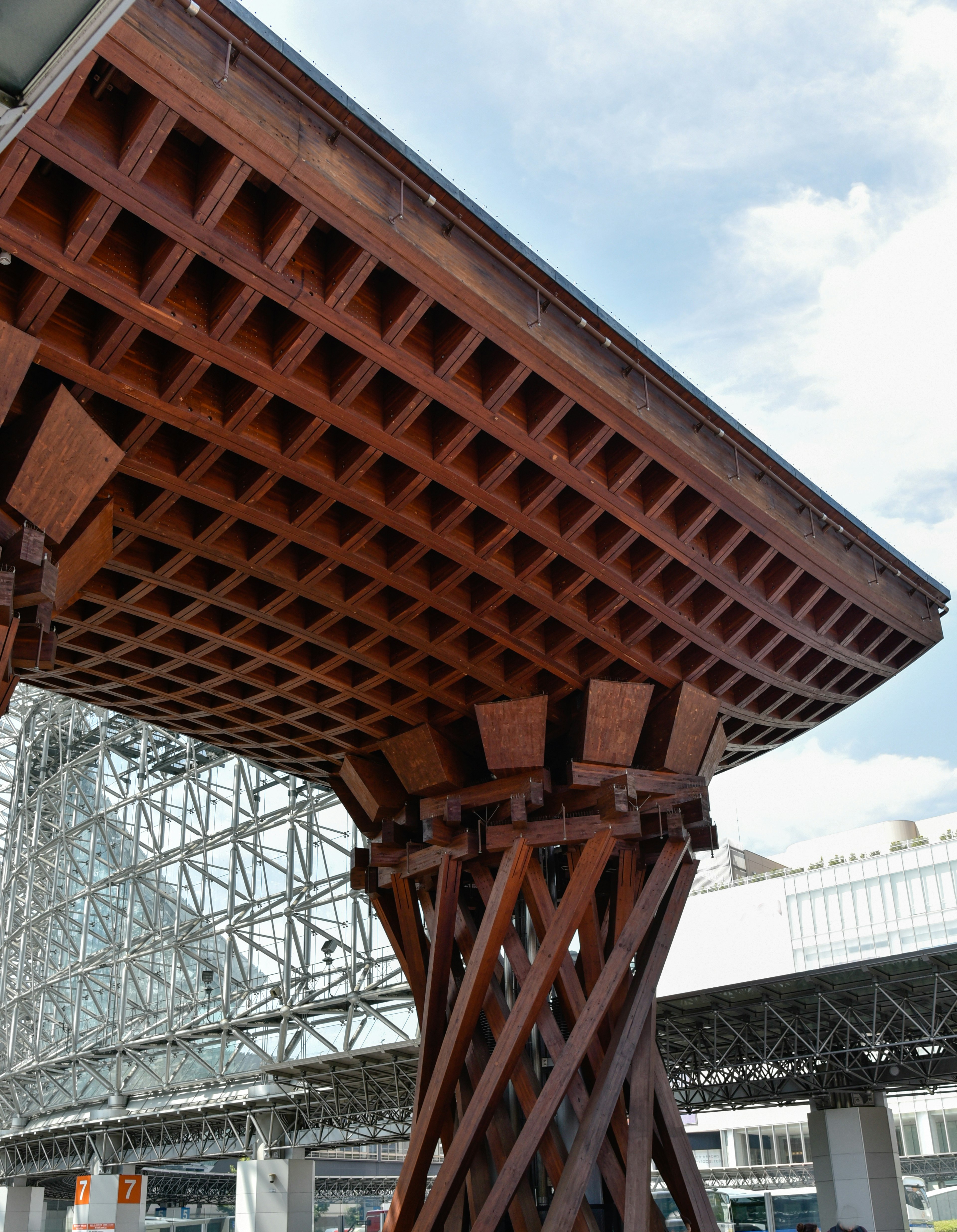 View from below of a wooden structure showcasing a grid design and unique supports