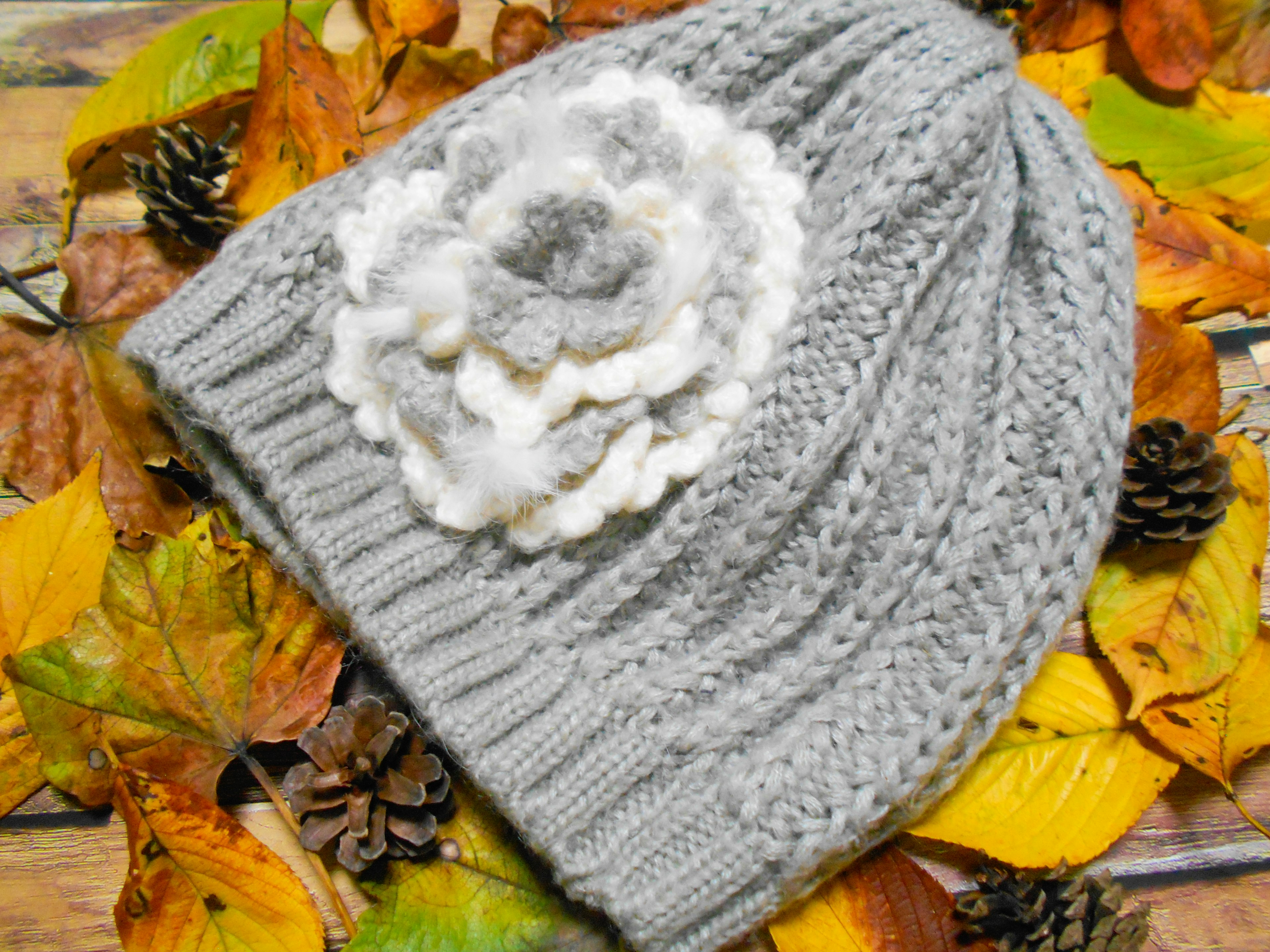 Gray knitted hat with a white flower decoration