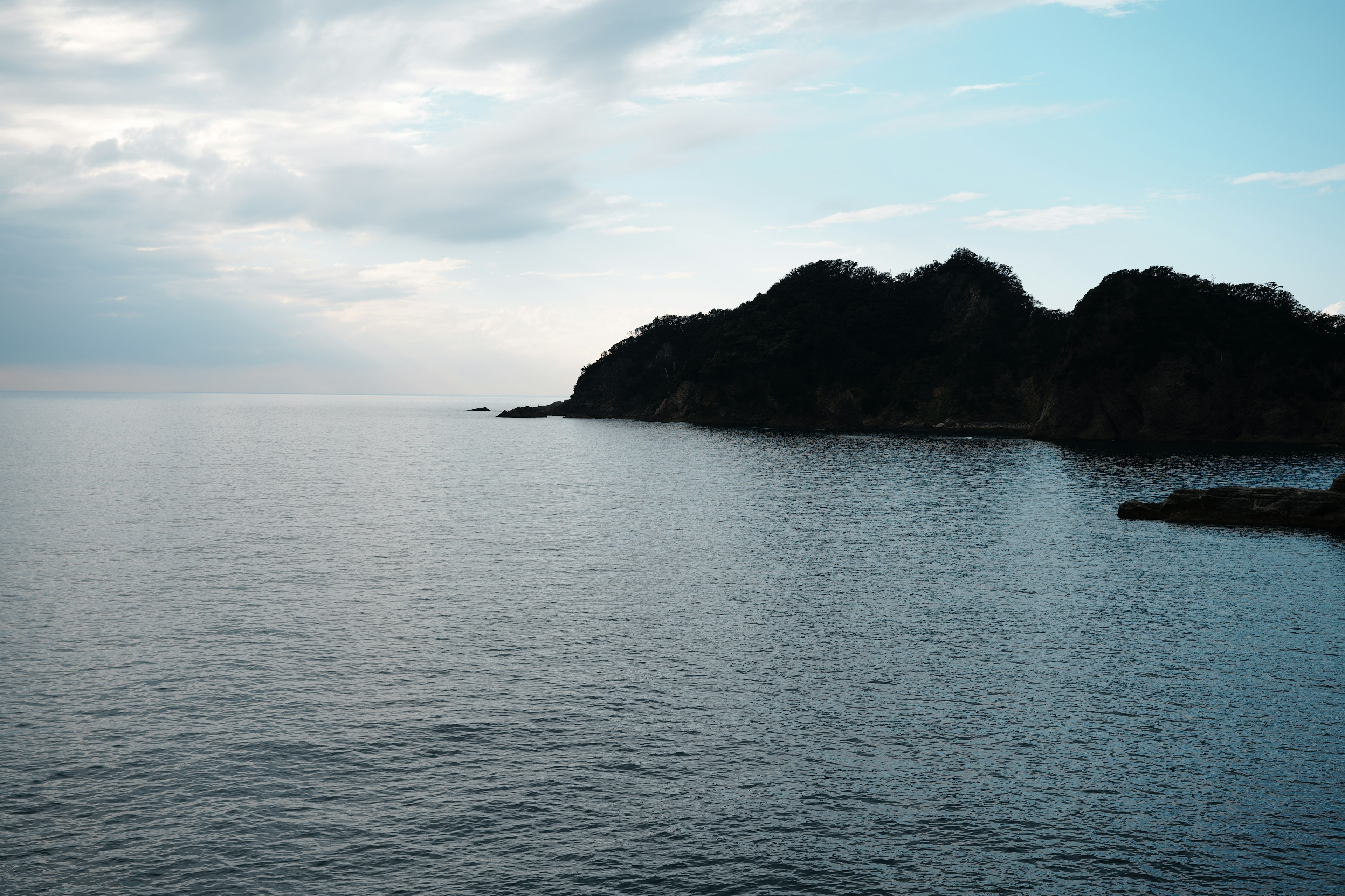 穏やかな海の風景と遠くの山影