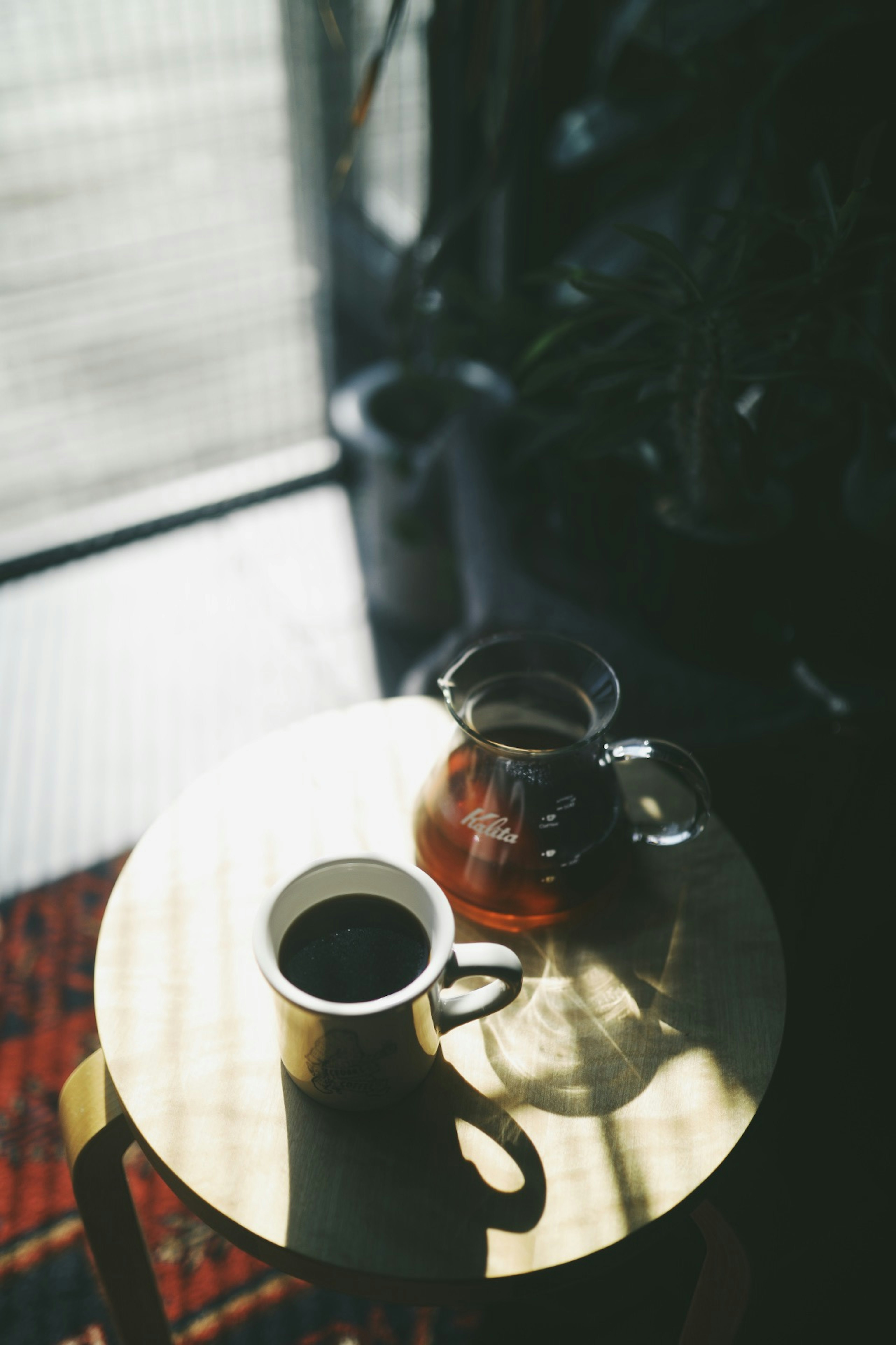 A coffee cup and a teapot on a round table