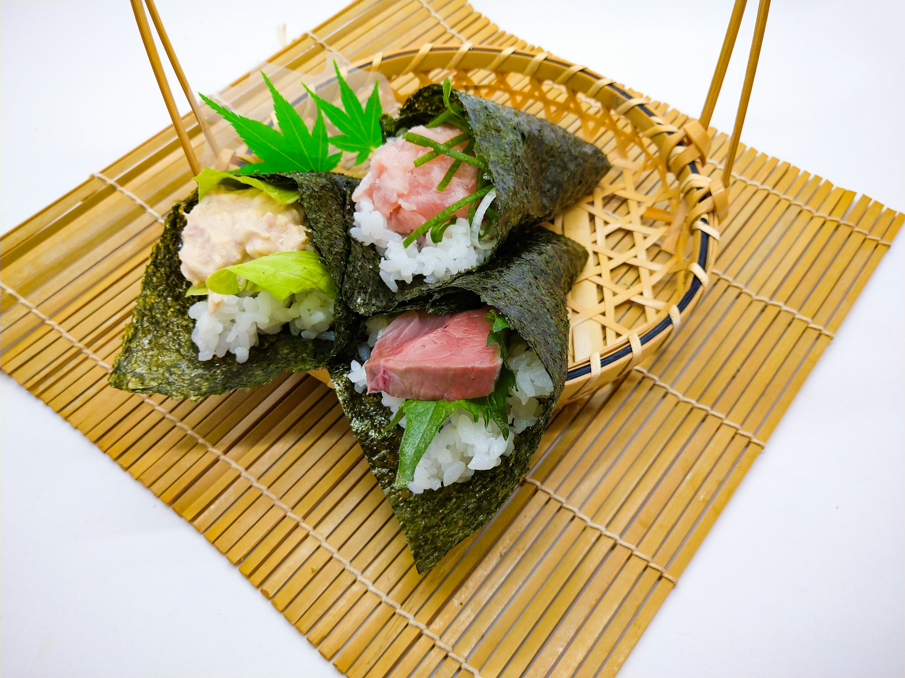 Un cestino con bellissimi rotoli di sushi posato su un tappetino di bambù