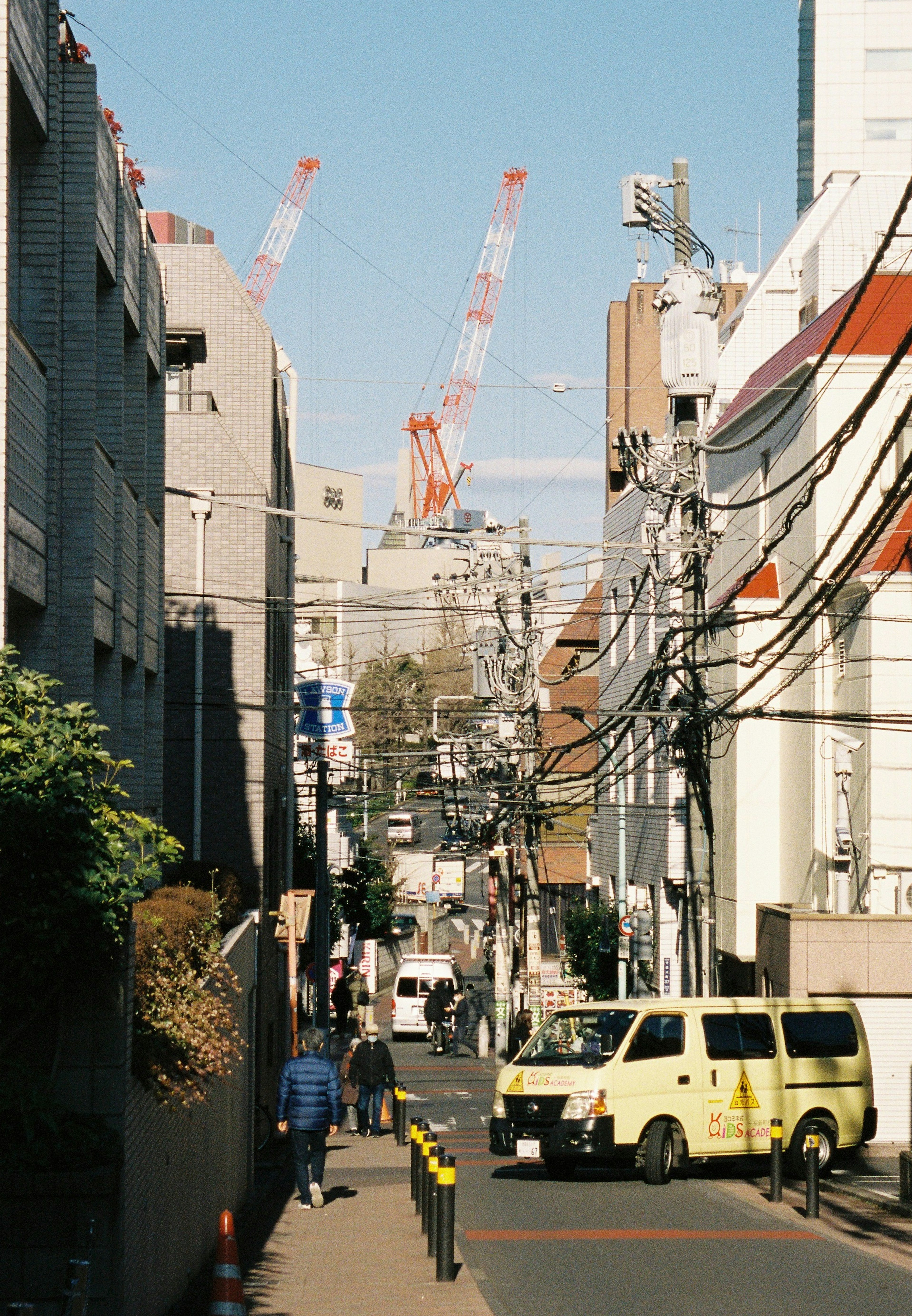 Urban street scene with visible construction cranes