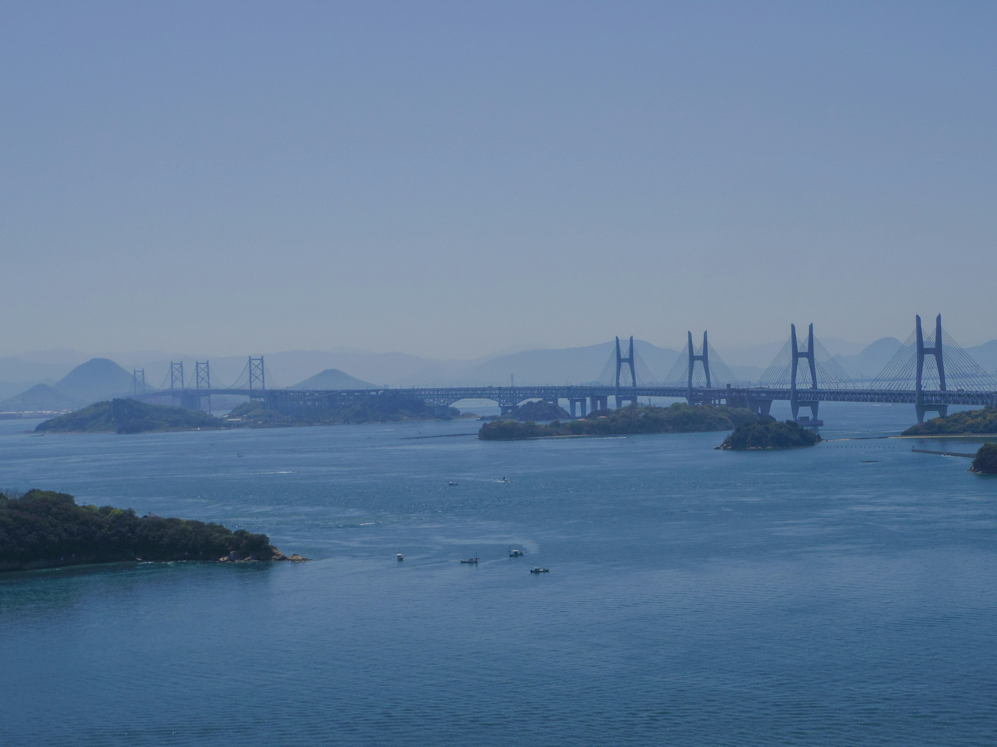 Pemandangan indah dengan jembatan di atas air tenang dan biru