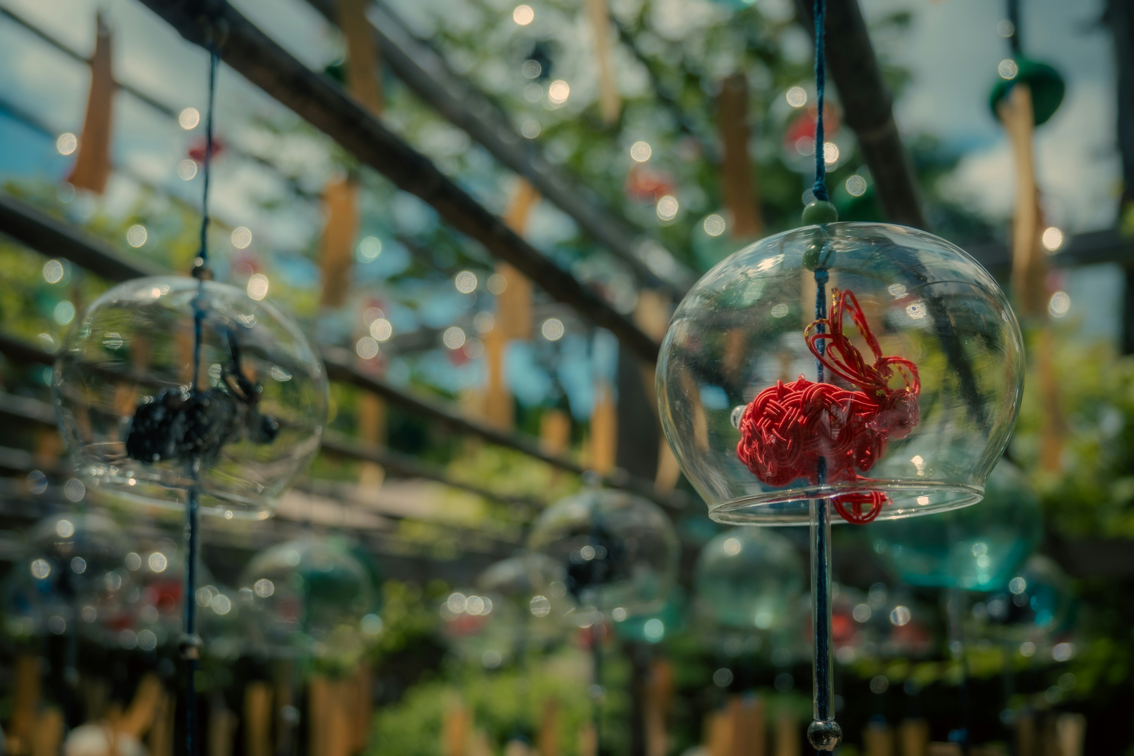 Carillons colorés suspendus dans un jardin avec des globes en verre et des éléments décoratifs