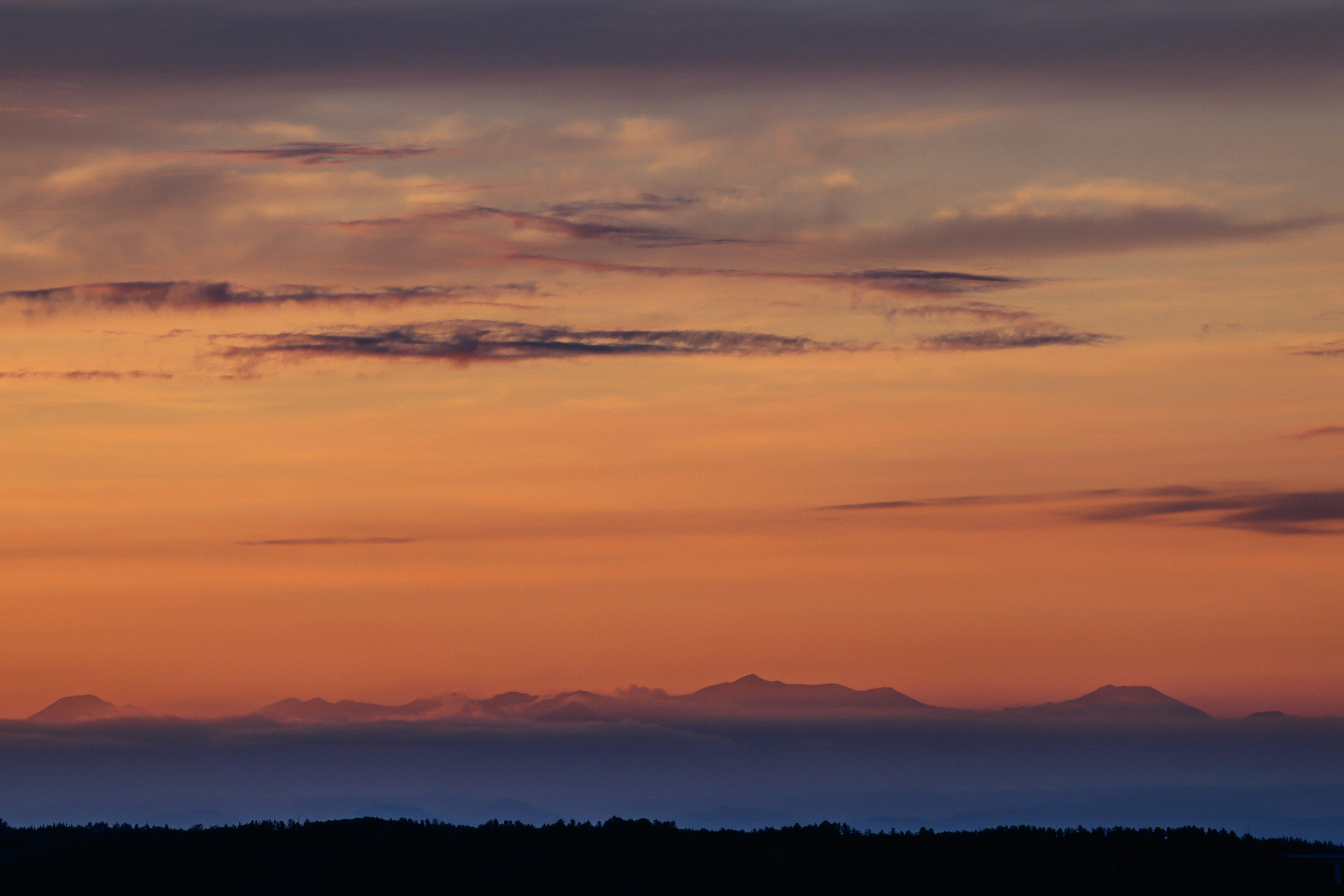 Landschaft mit Sonnenuntergangshimmel und fernen Bergen