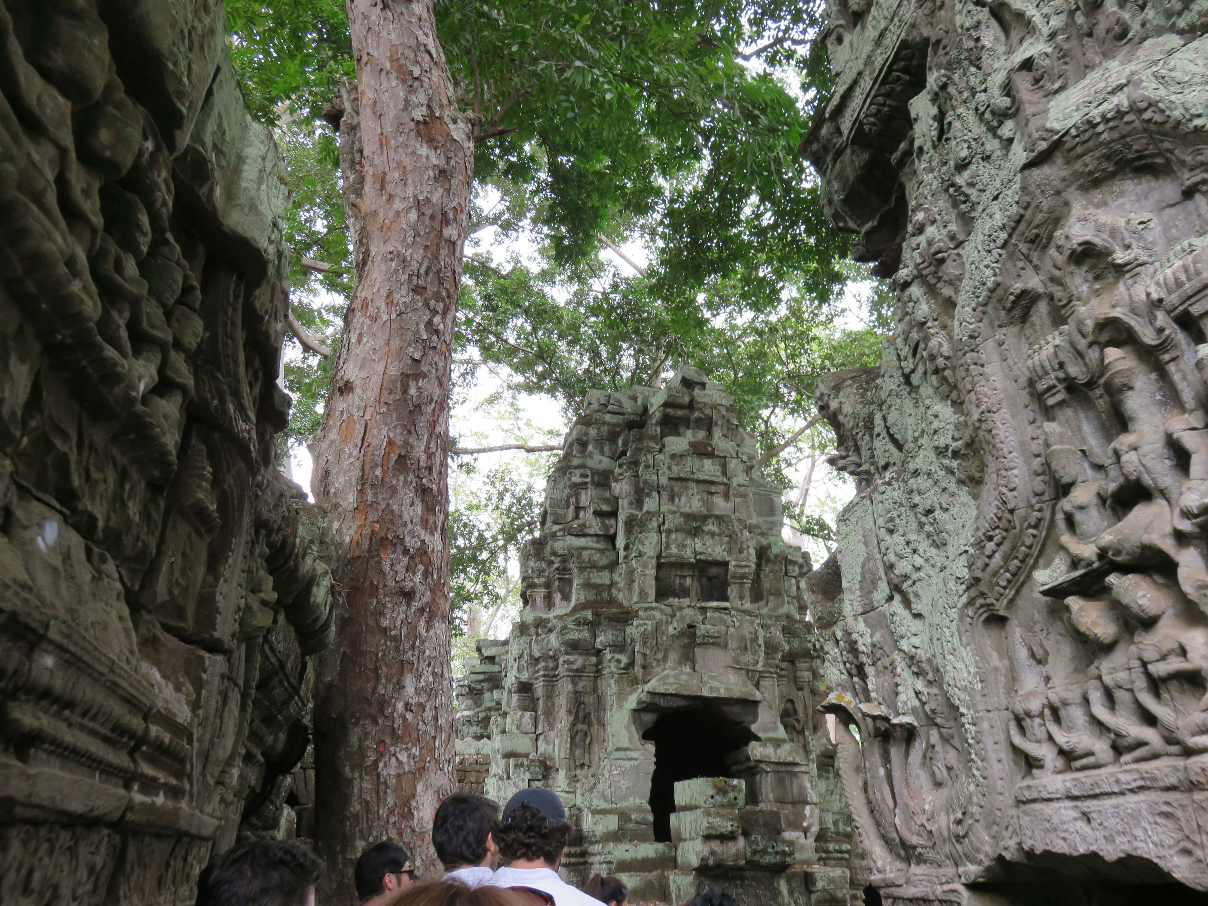 Ancient temple ruins surrounded by lush greenery and people