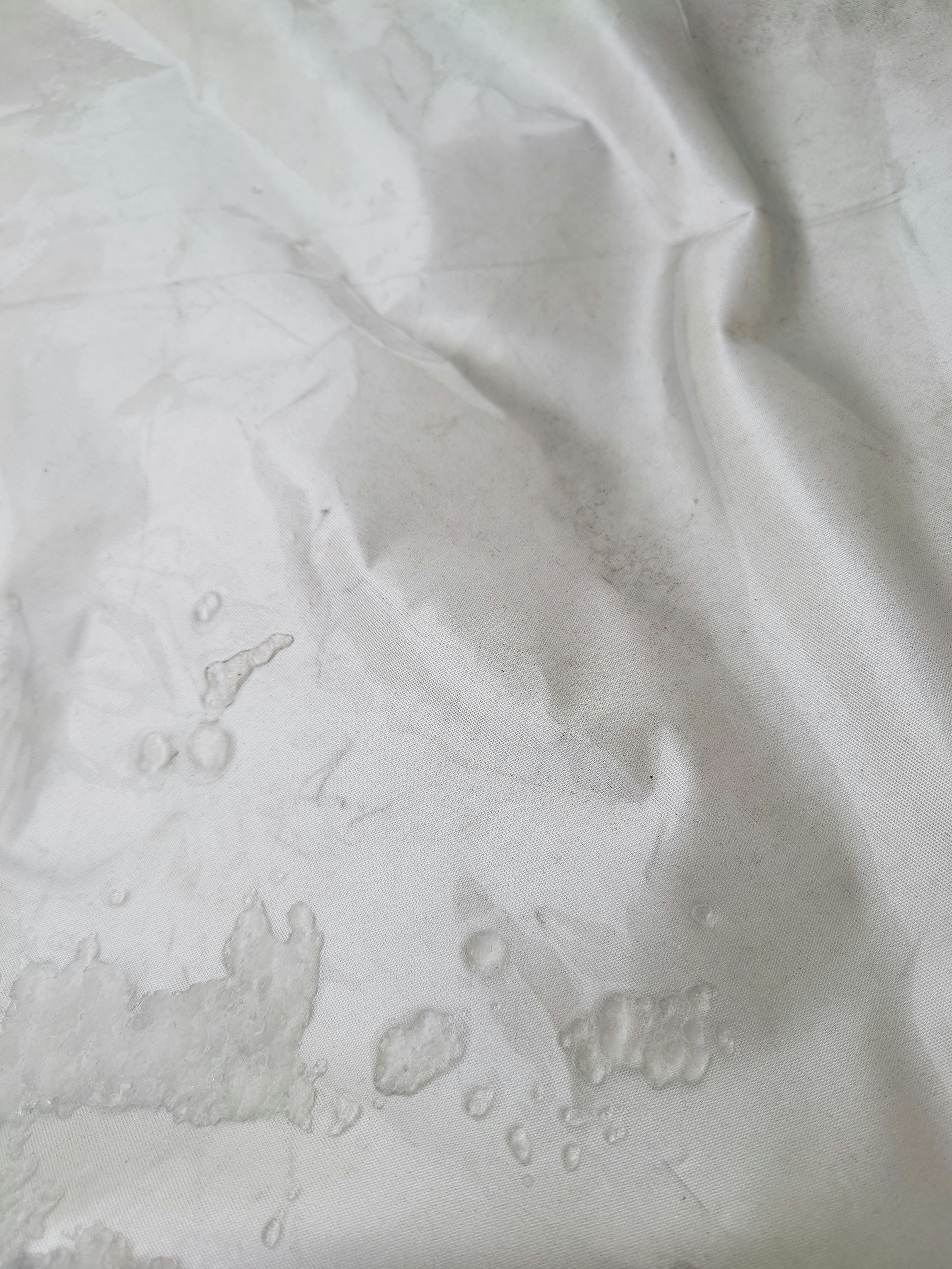 Image of a white fabric with water droplets showcasing a soft texture