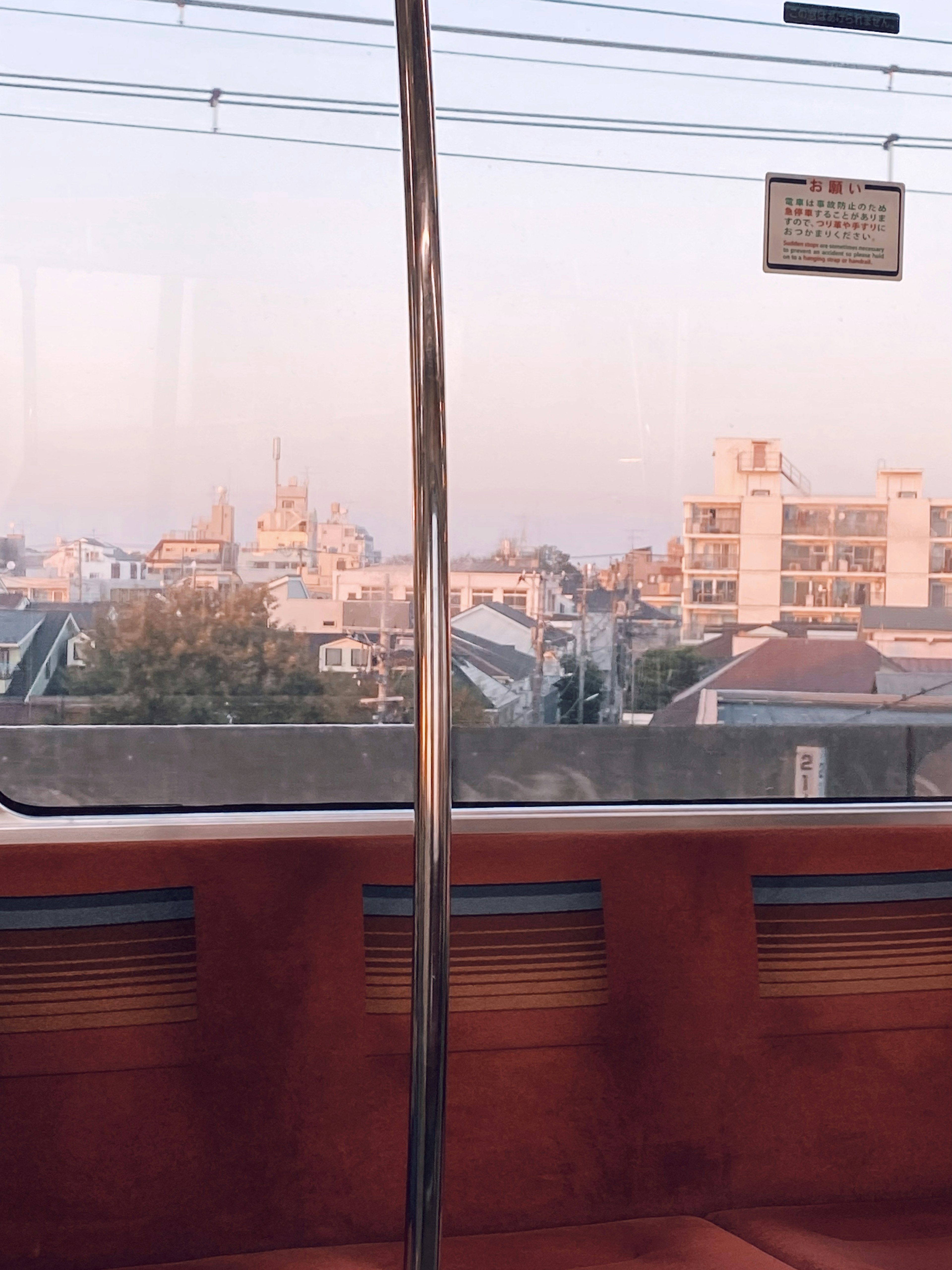 Vista di un paesaggio urbano dall'interno di un treno con tonalità di tramonto