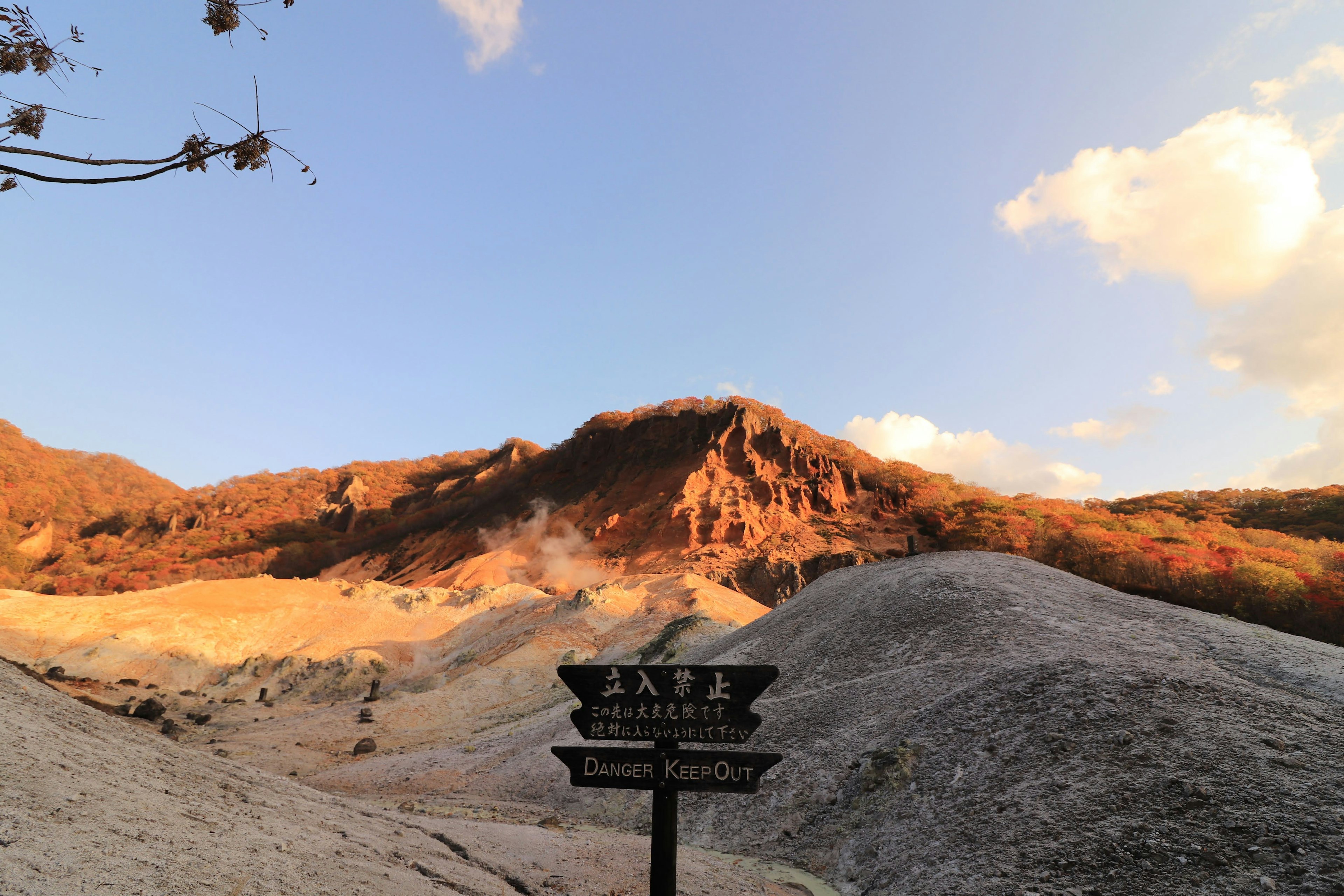 Vista panorámica de una montaña con un letrero que indica una fuente termal