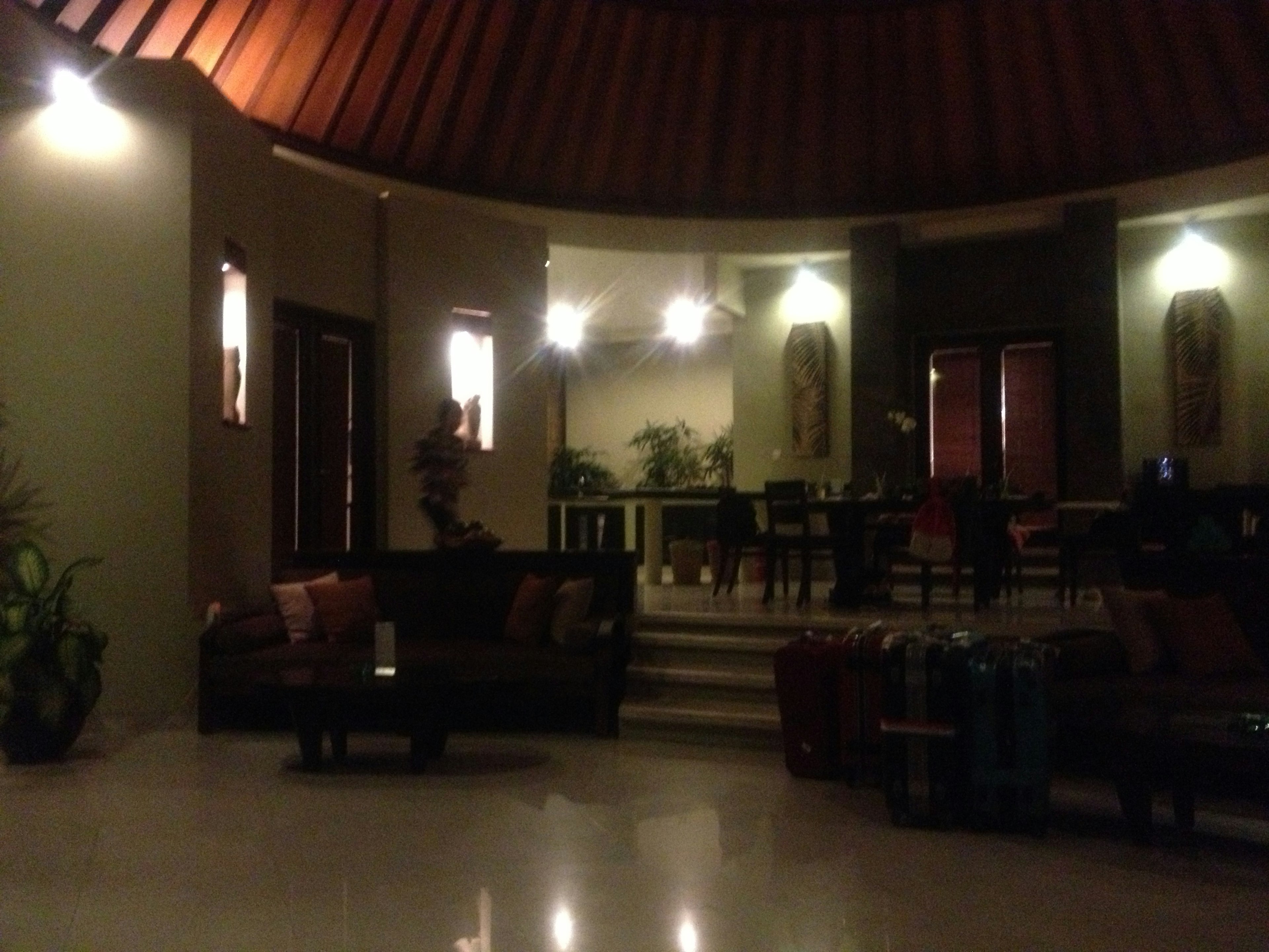 Area lounge nyaman dengan sofa dan meja di ruangan yang redup