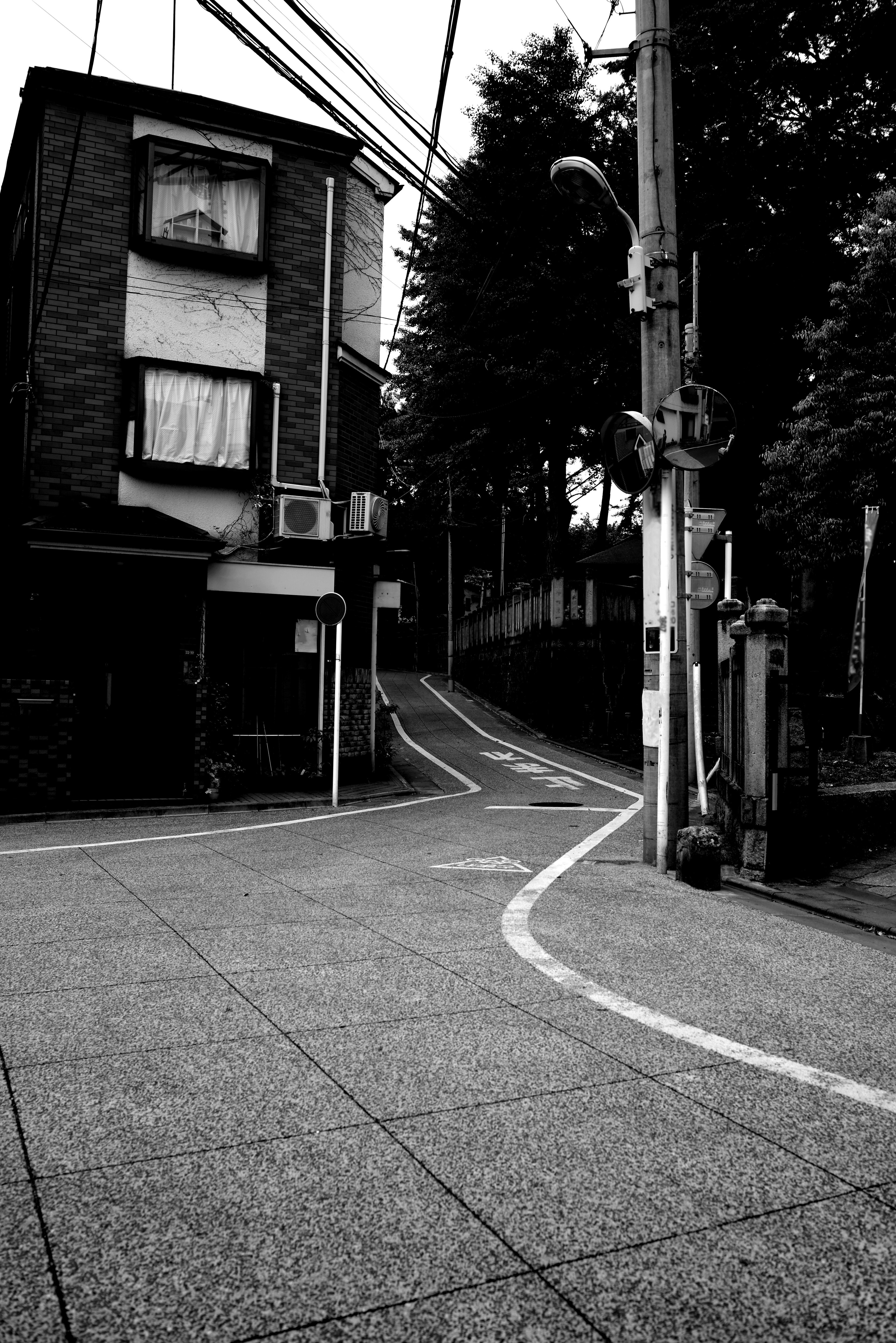 Curved road at a street corner with an old building in black and white