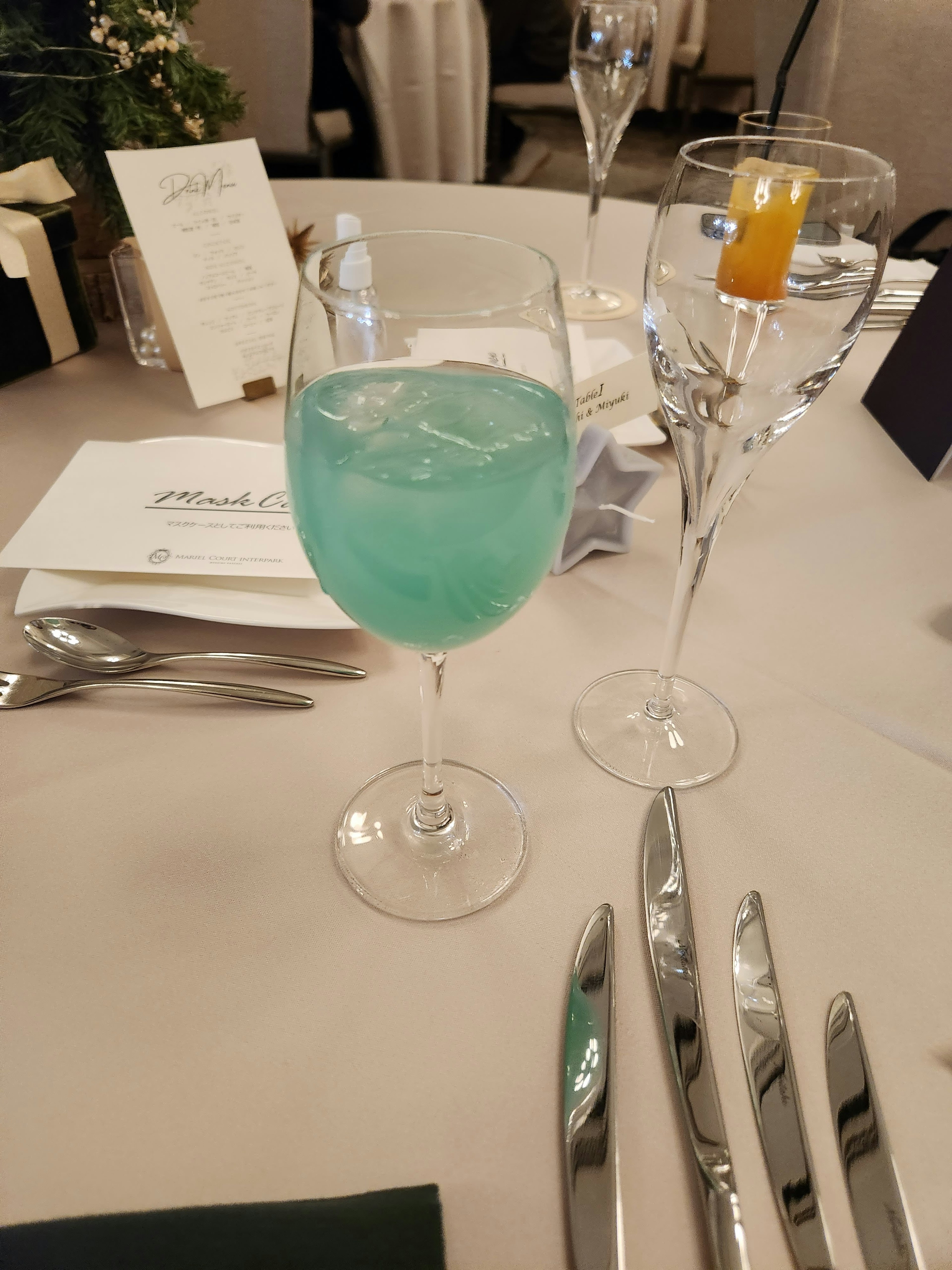 Ein blauer Cocktailglas und ein klares Weinglas auf einem Esstisch