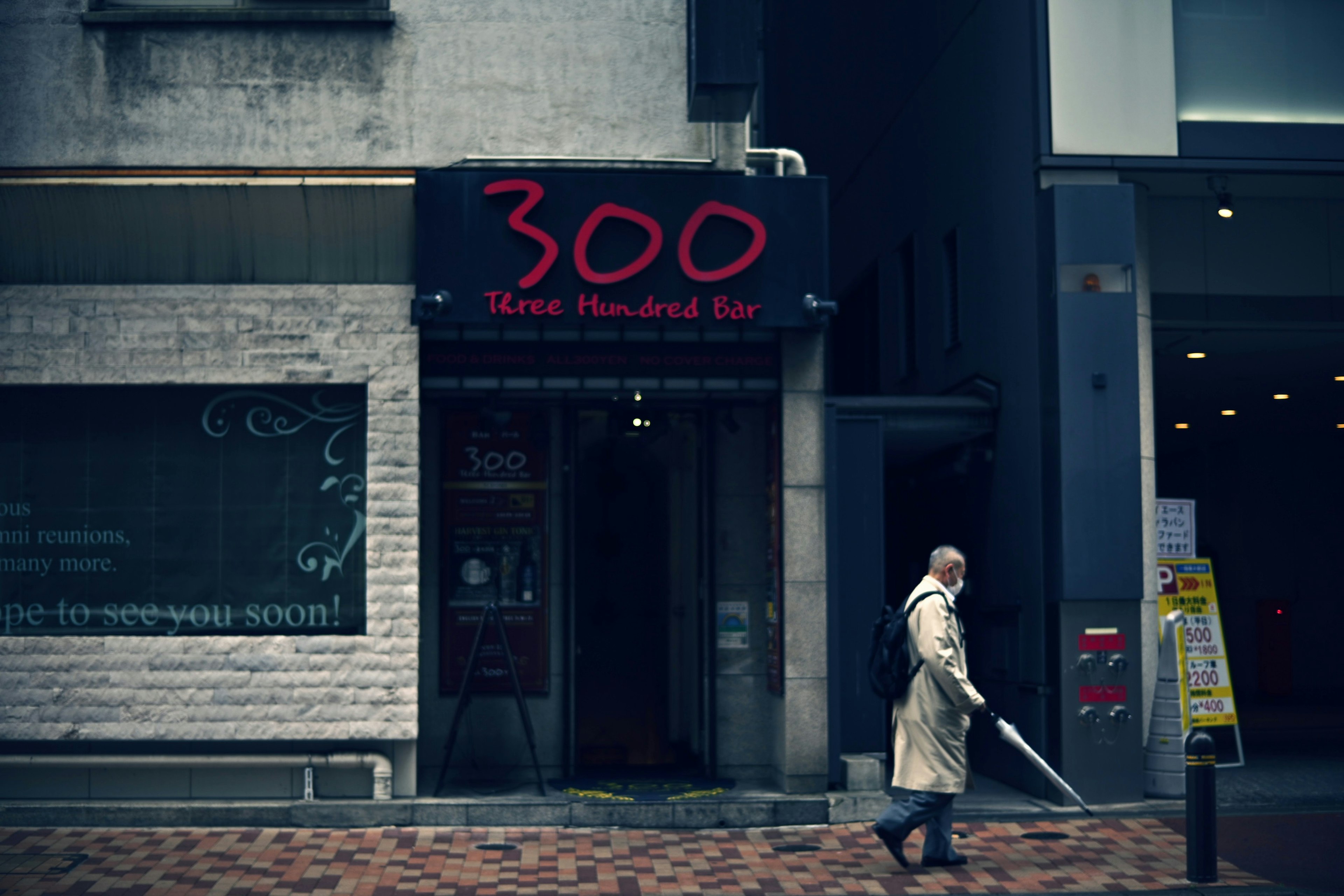 Une personne marchant devant un bar nommé 300