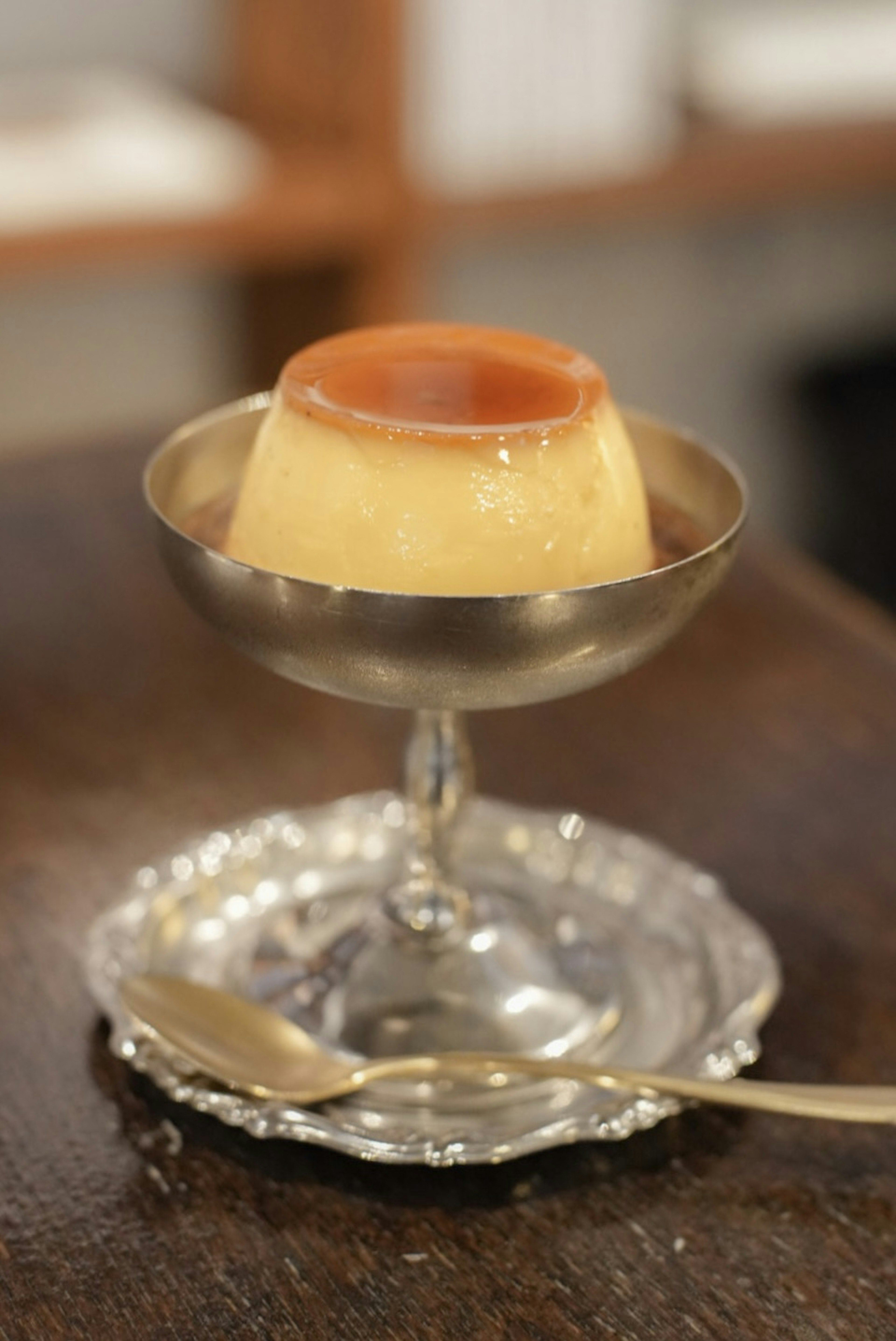 Creamy pudding served in a silver dish on a decorative plate