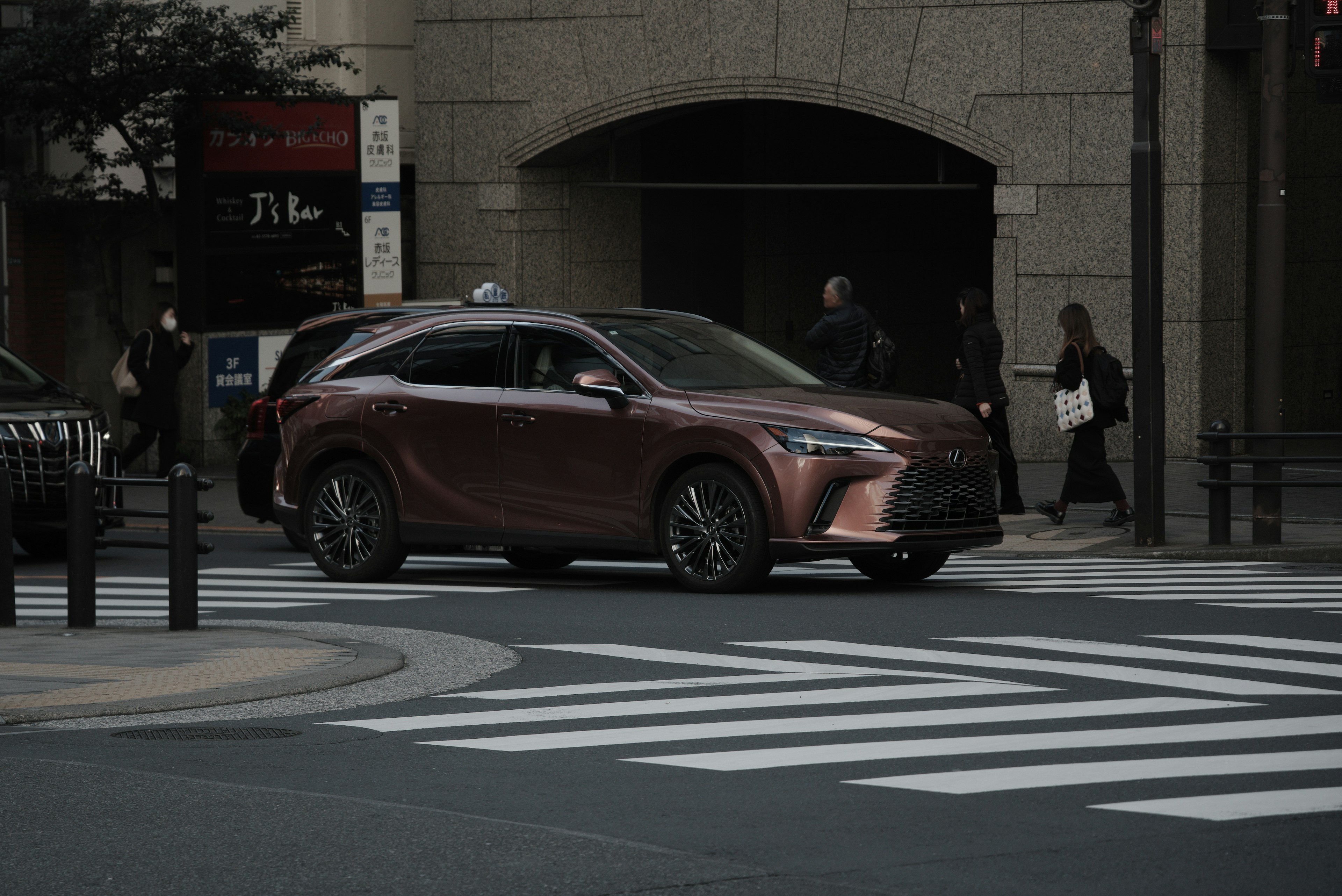 Ein roter Lexus SUV, der an einer Kreuzung abbiegt