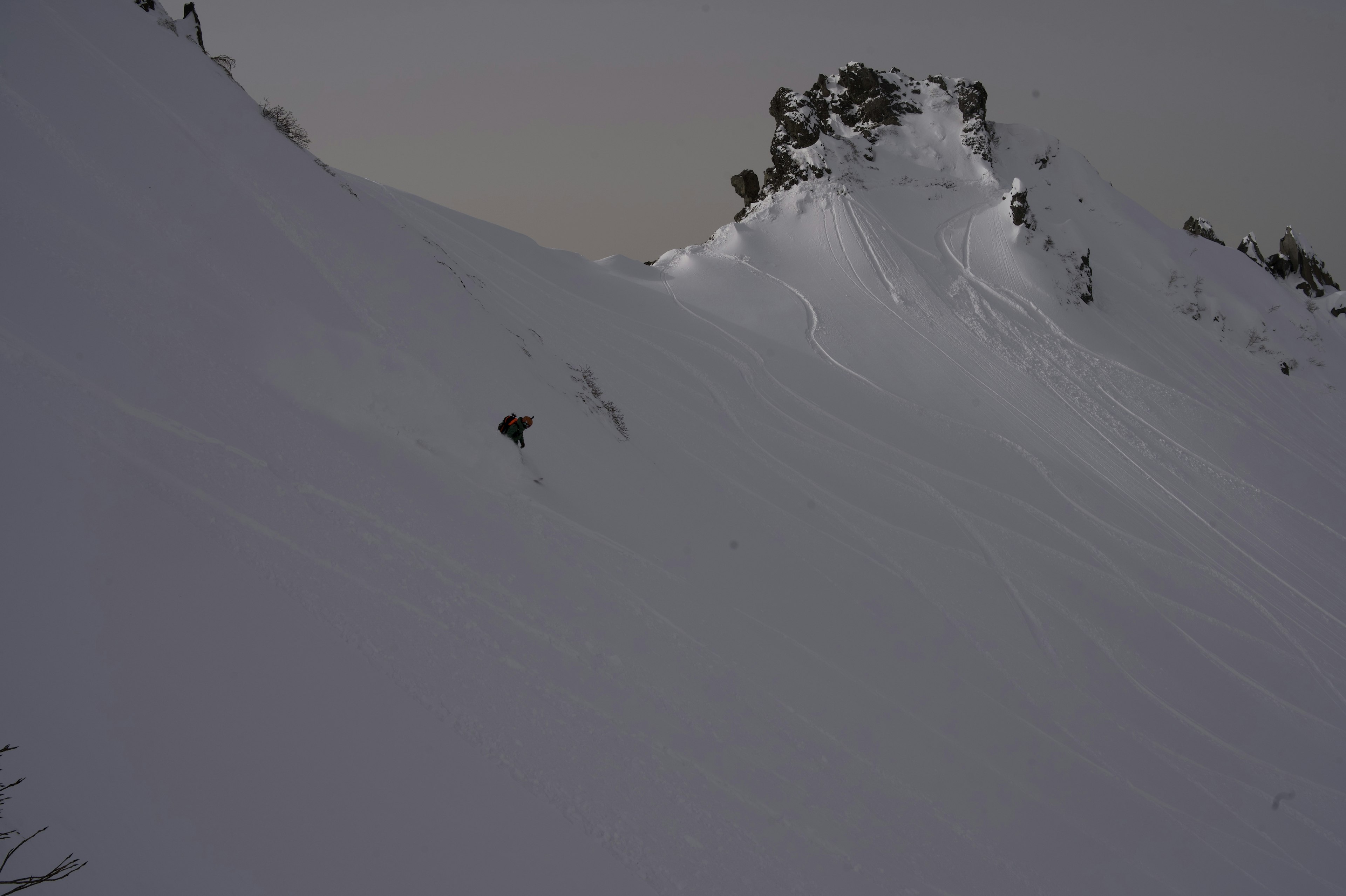 Schneebedeckte Bergneigung mit felsigem Vorsprung