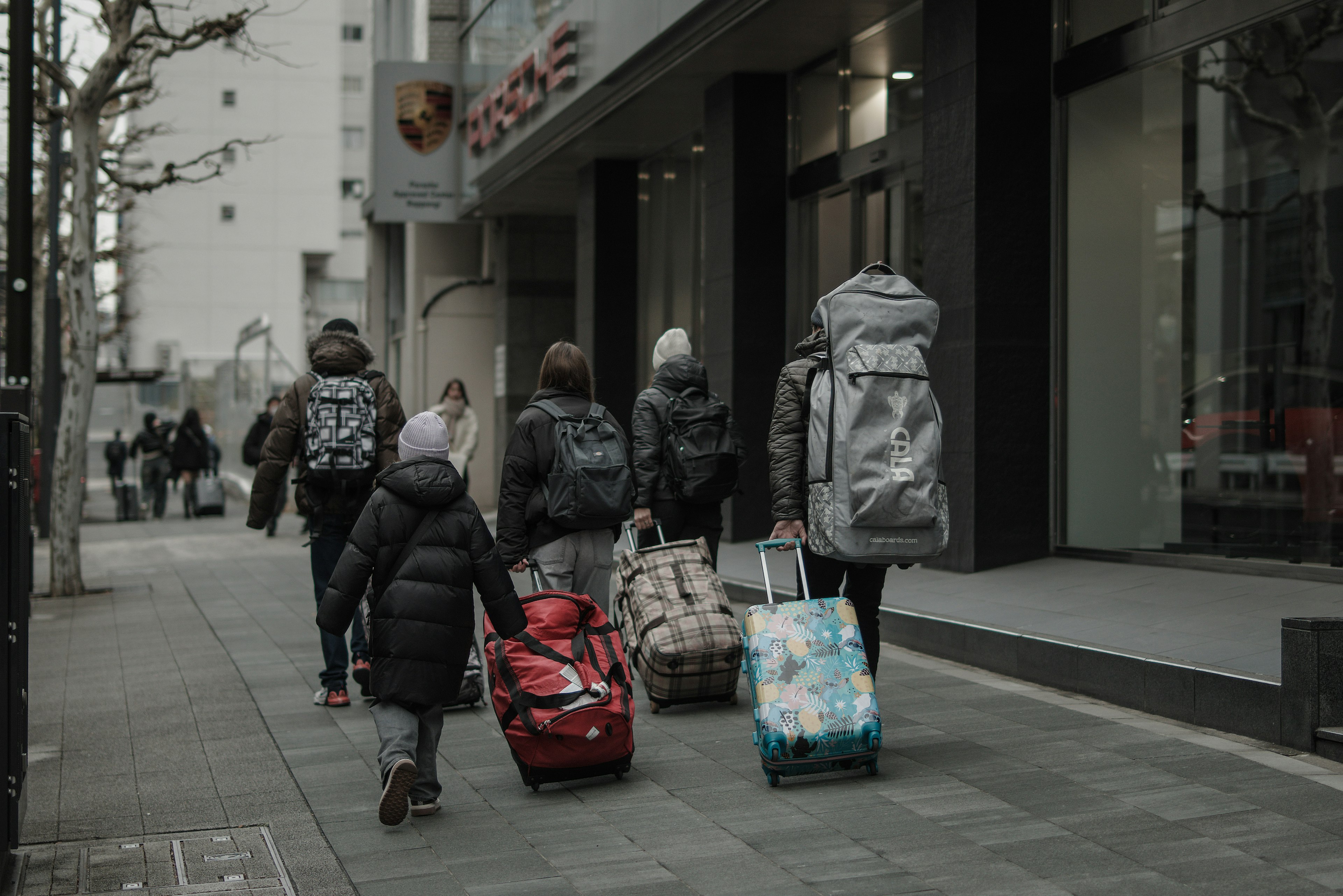 Famiglia che cammina con bagagli per strada