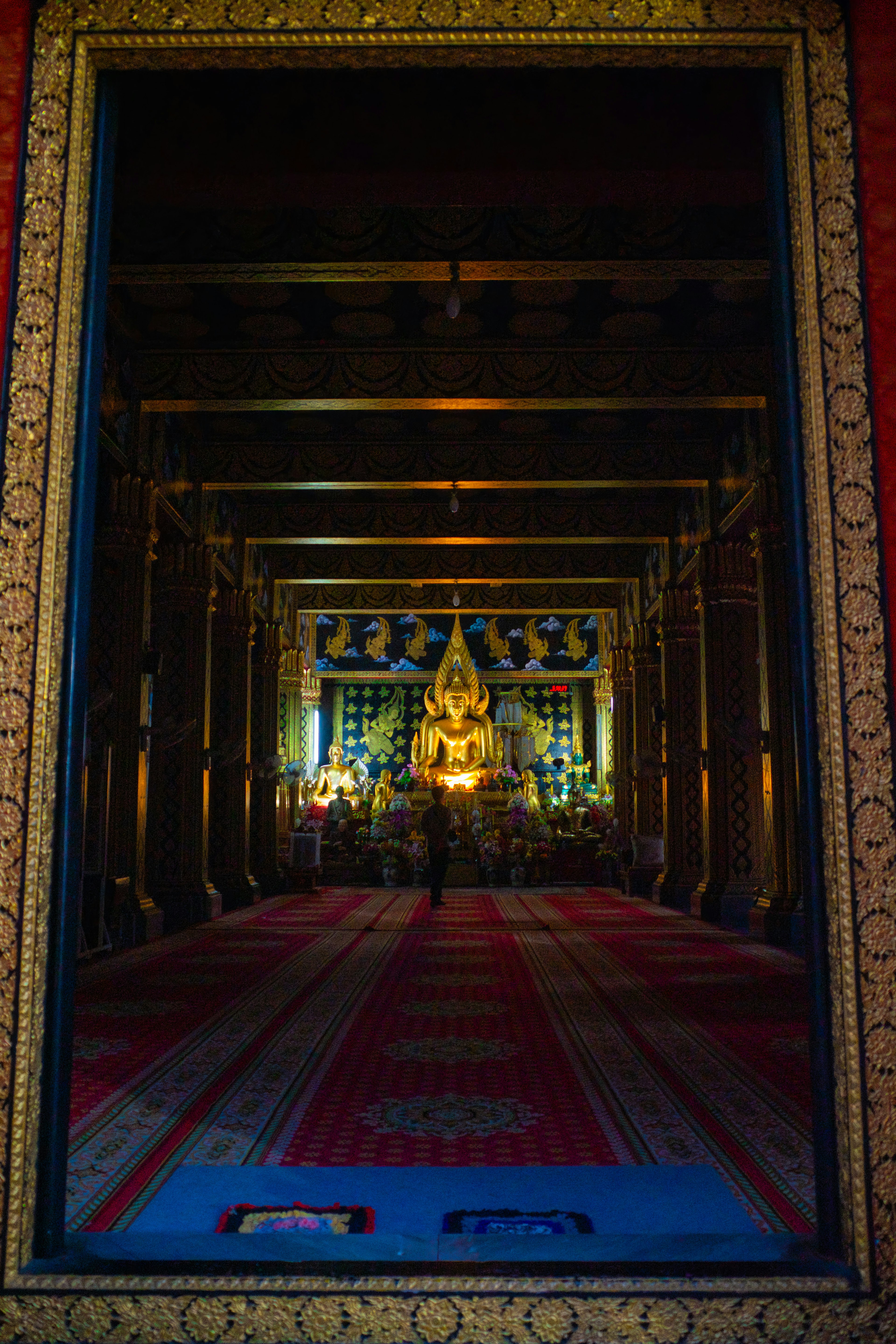 View of a temple interior featuring a golden Buddha statue