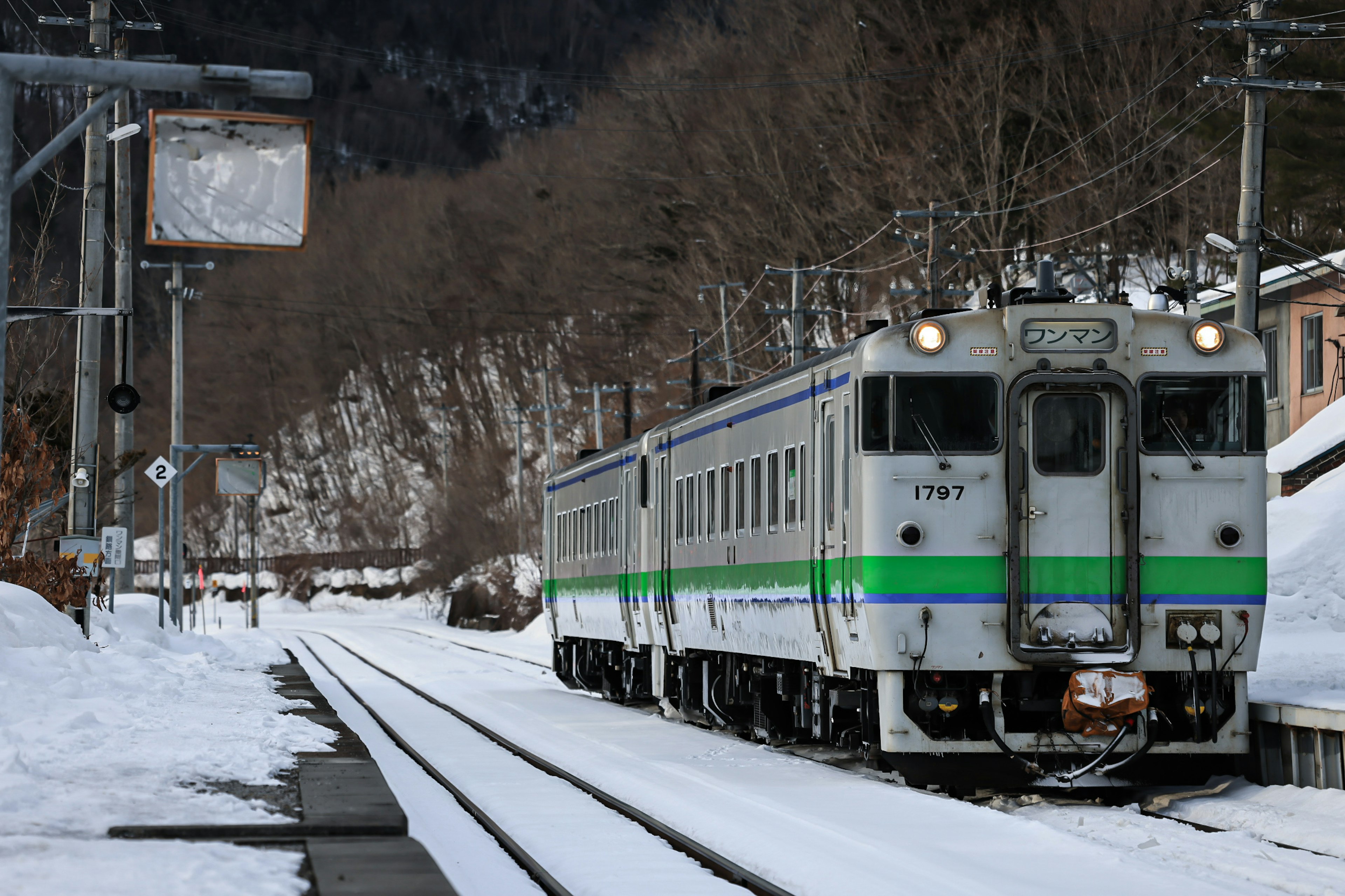 Tren detenido en vías nevadas con un viejo reloj de estación