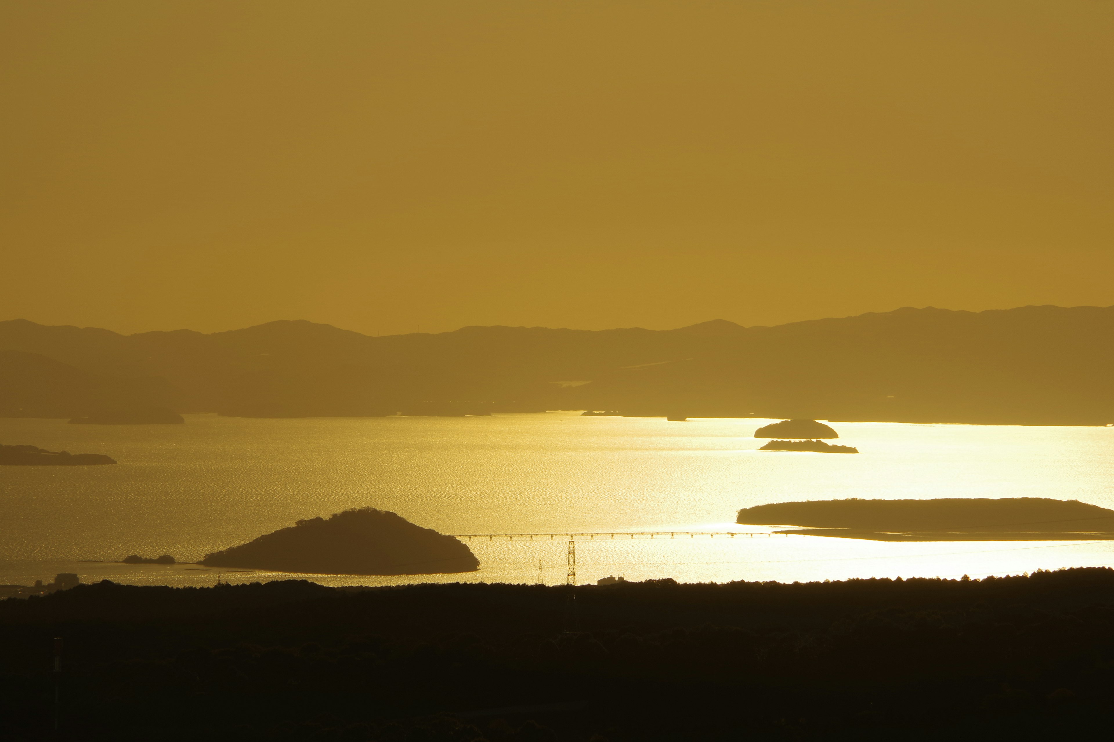 夕日が反射する海と島々の風景