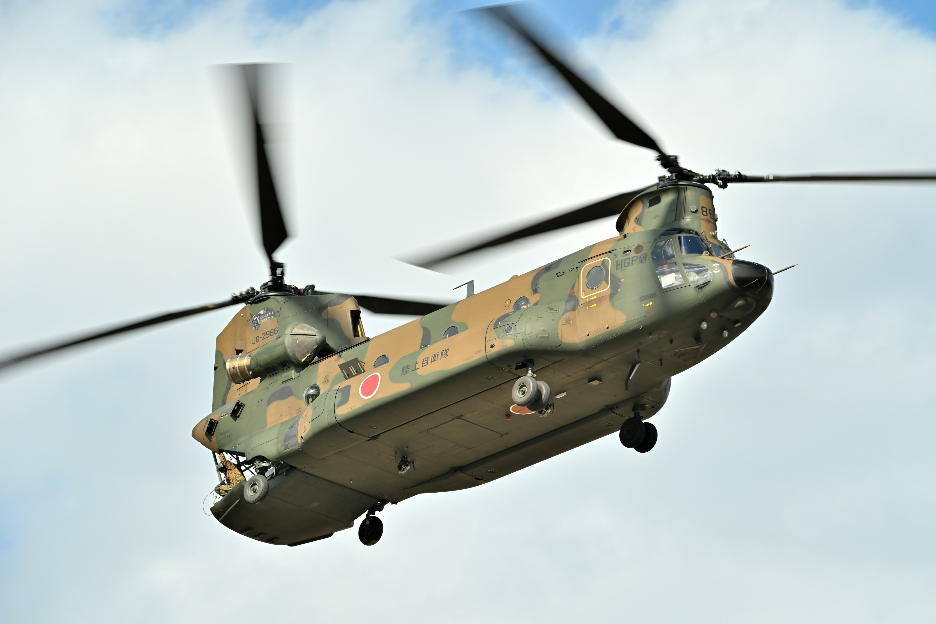 Military helicopter in flight with rotating blades