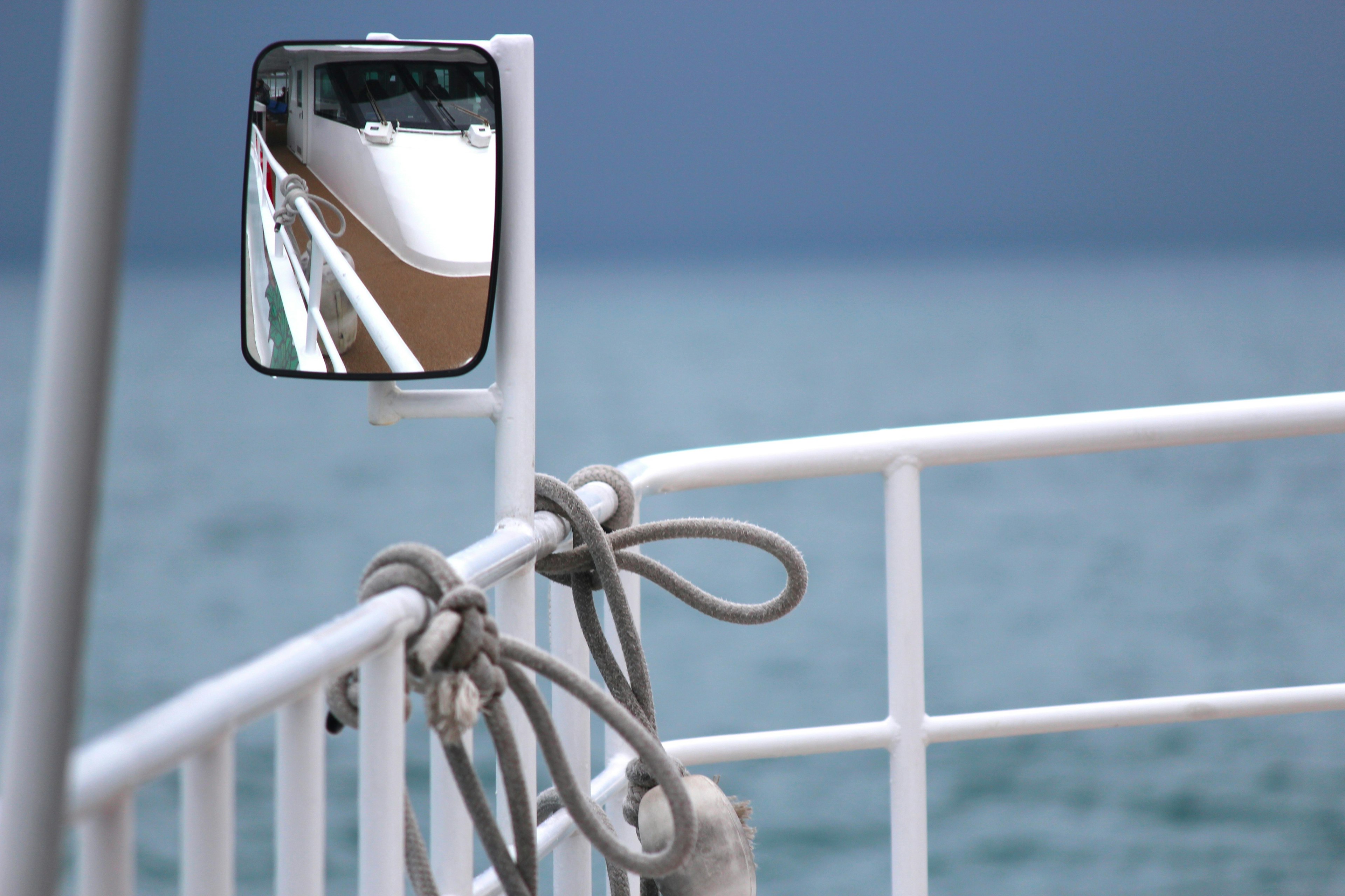 Bootsgeländer mit einem Spiegel, der das Meer reflektiert