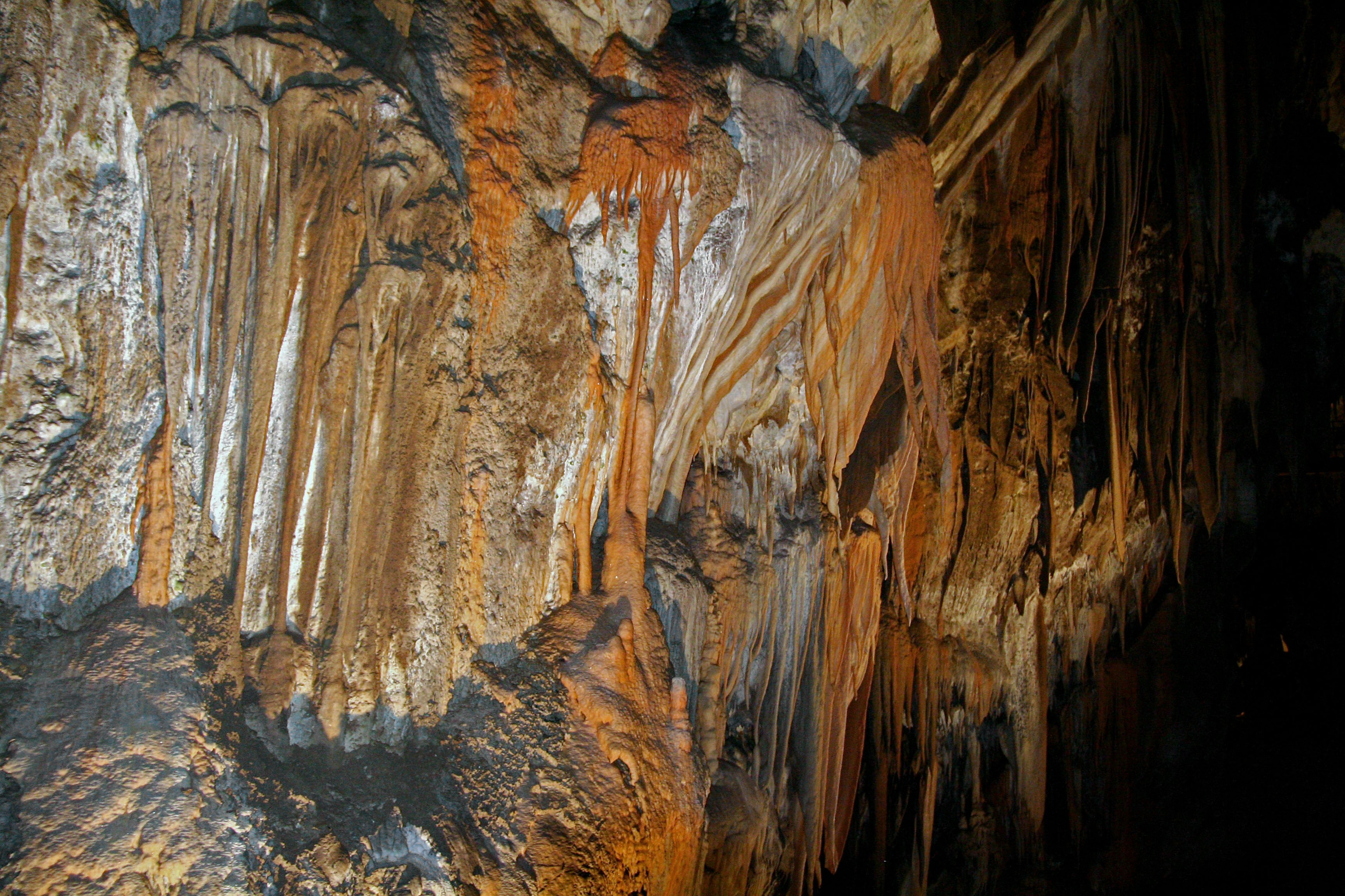 Textura detallada de estalactitas y estalagmitas en la pared de la cueva