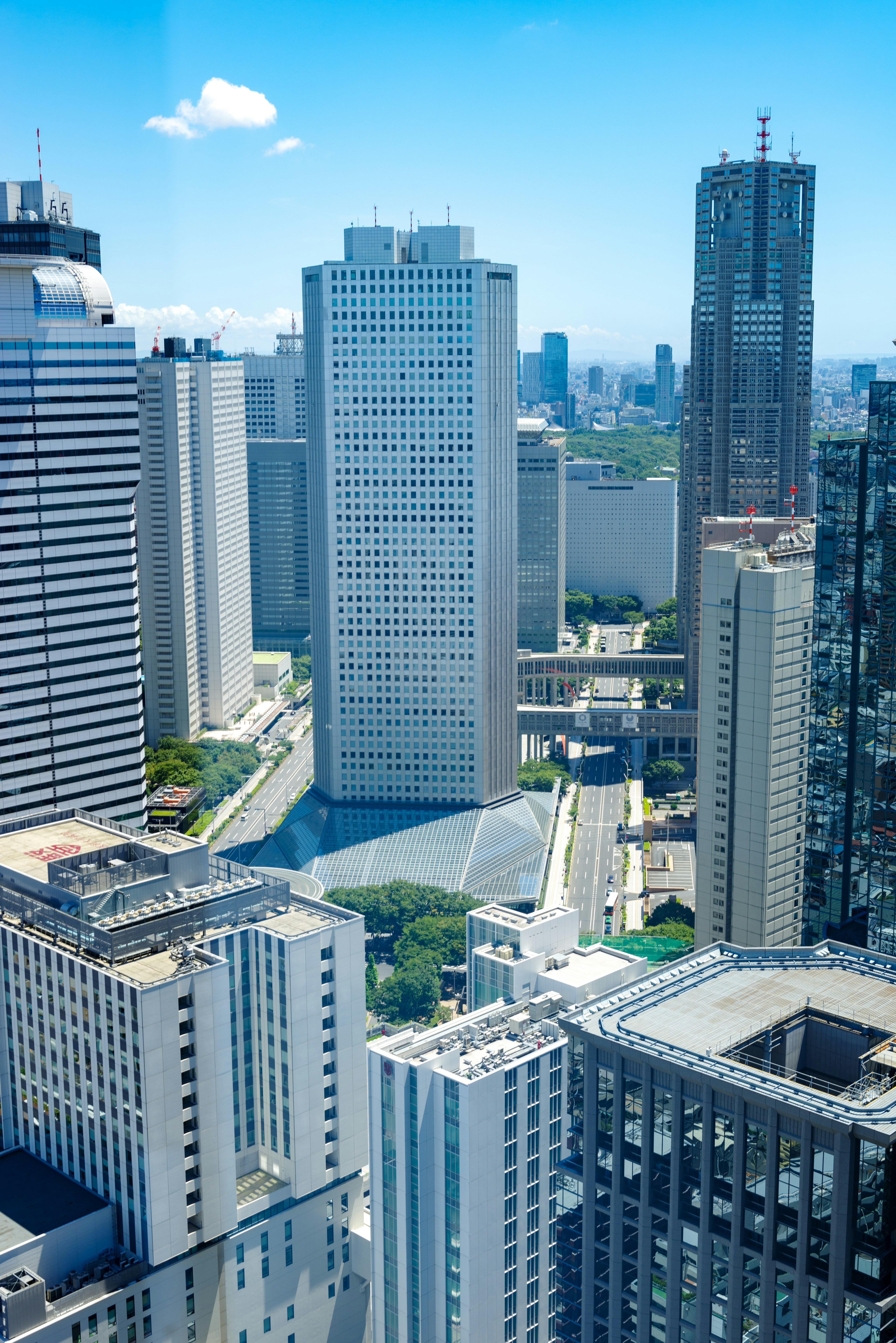 Cityscape with skyscrapers under a bright blue sky and clouds