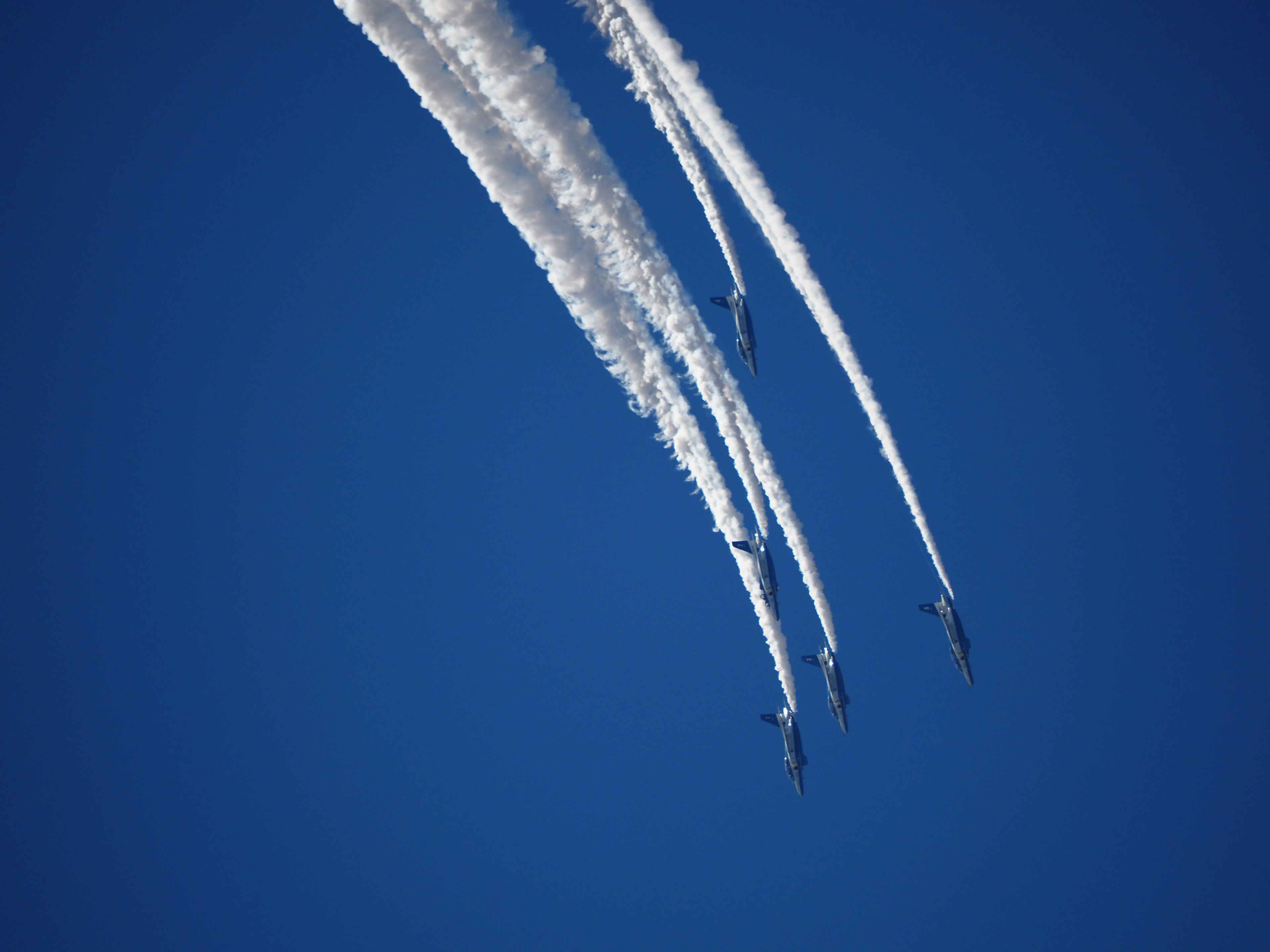 Grupo de aviones creando estelas blancas en un cielo azul