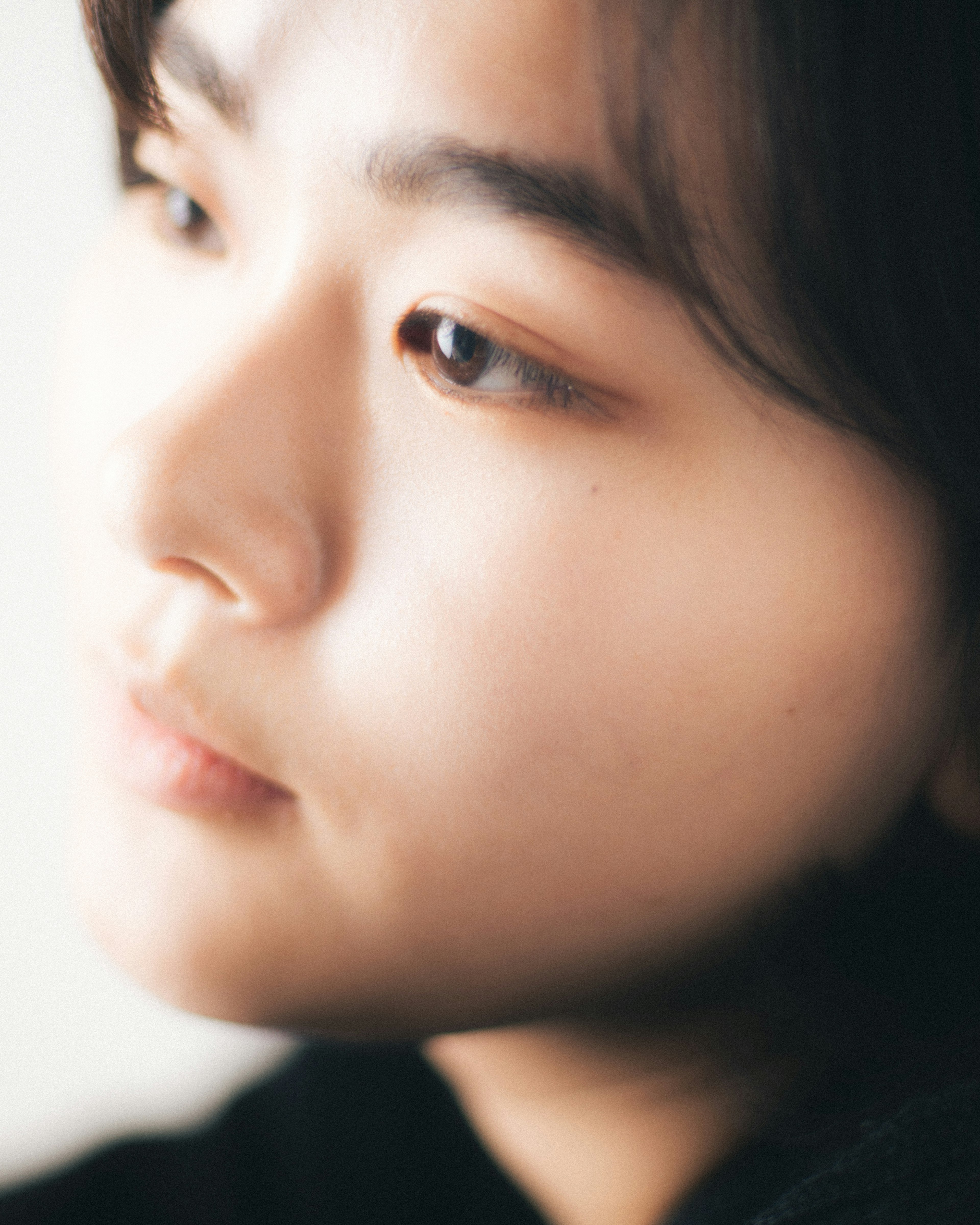 Side profile of a woman lost in thought with soft lighting