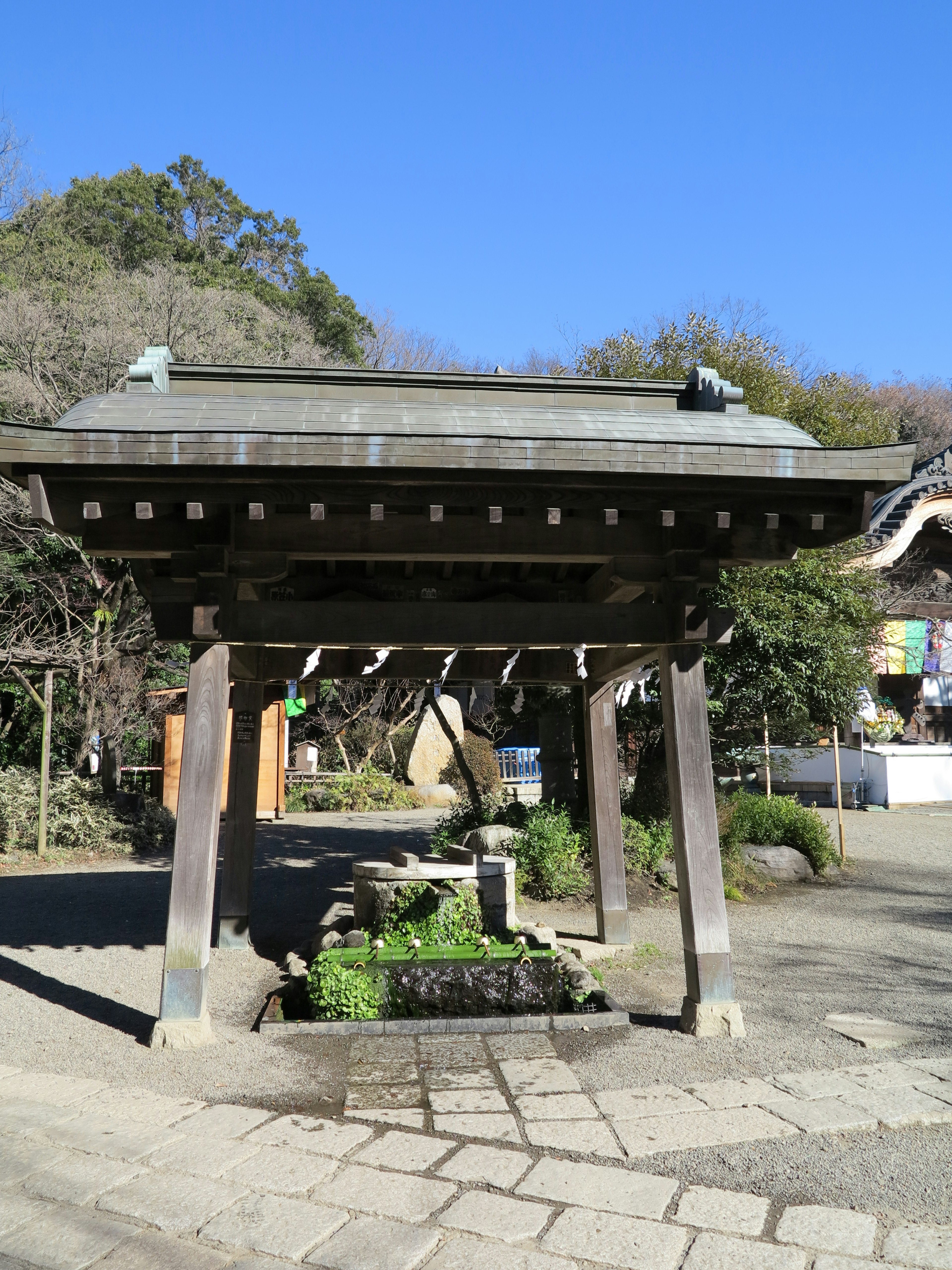 Traditional Japanese temple gate with stone water basin