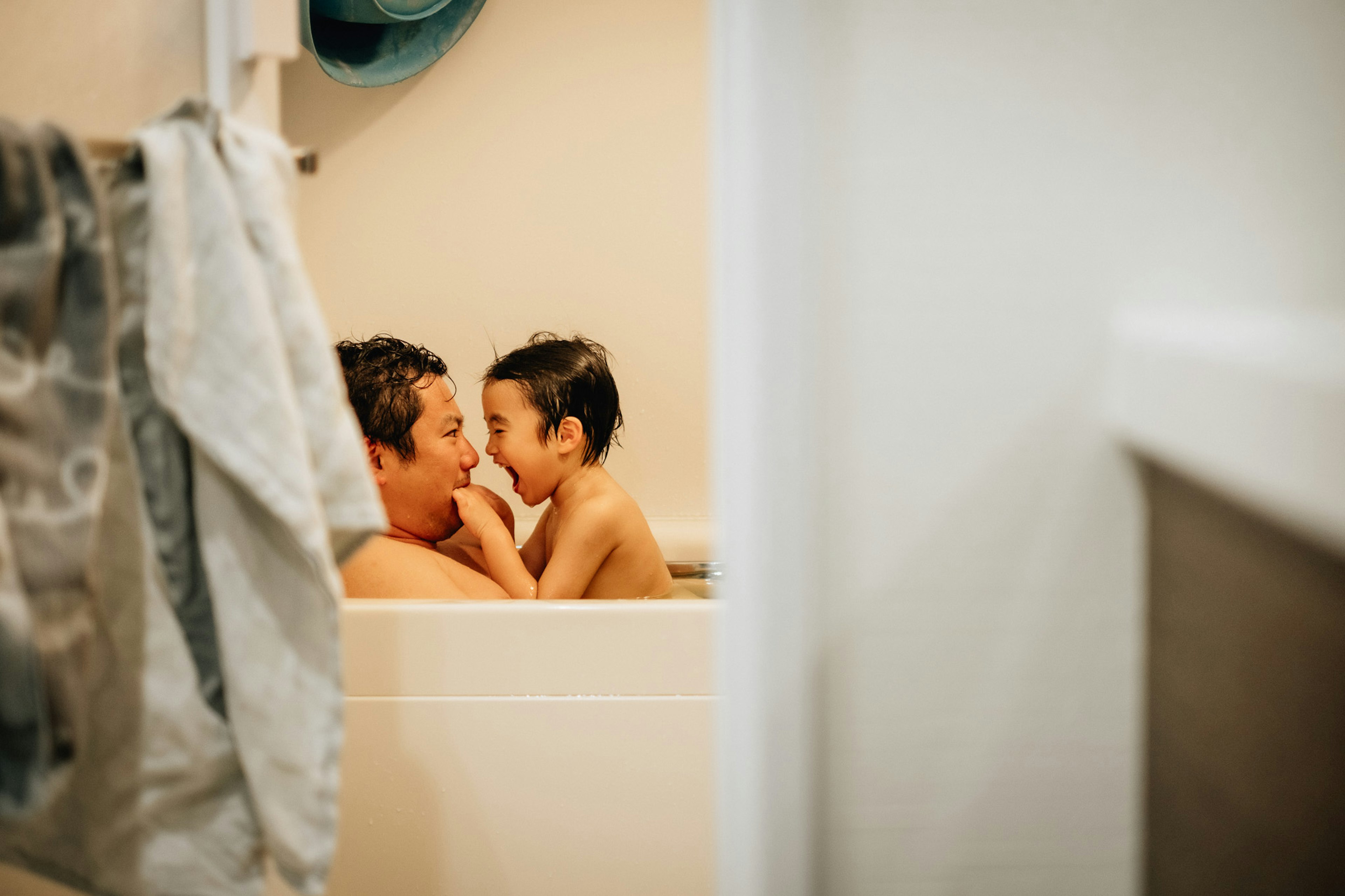 A warm moment between a father and son playing in the bath