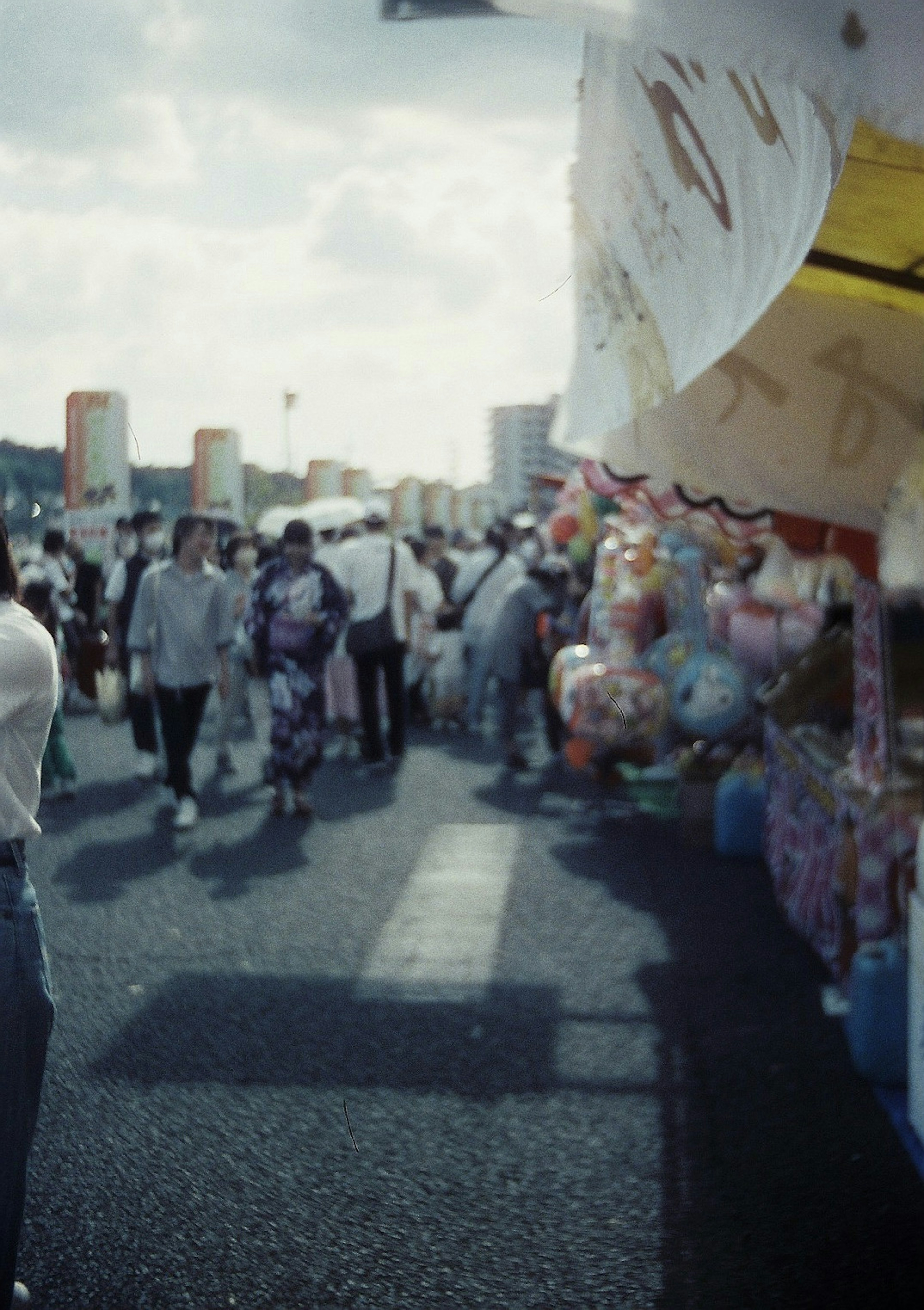 Una escena de festival animada con coloridos puestos y multitudes de personas caminando