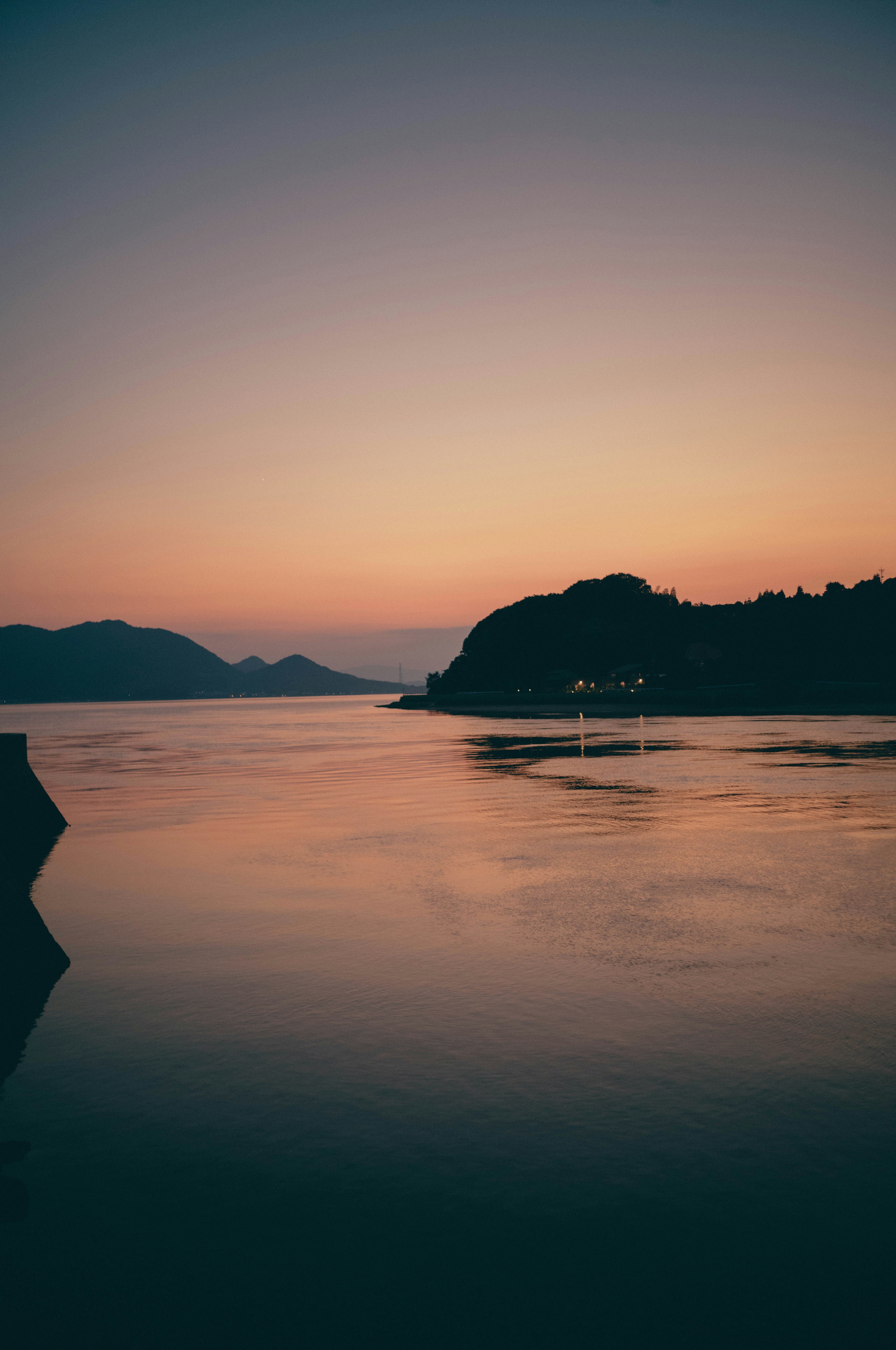 夕暮れの海と山の風景 静かな水面と柔らかな色合い