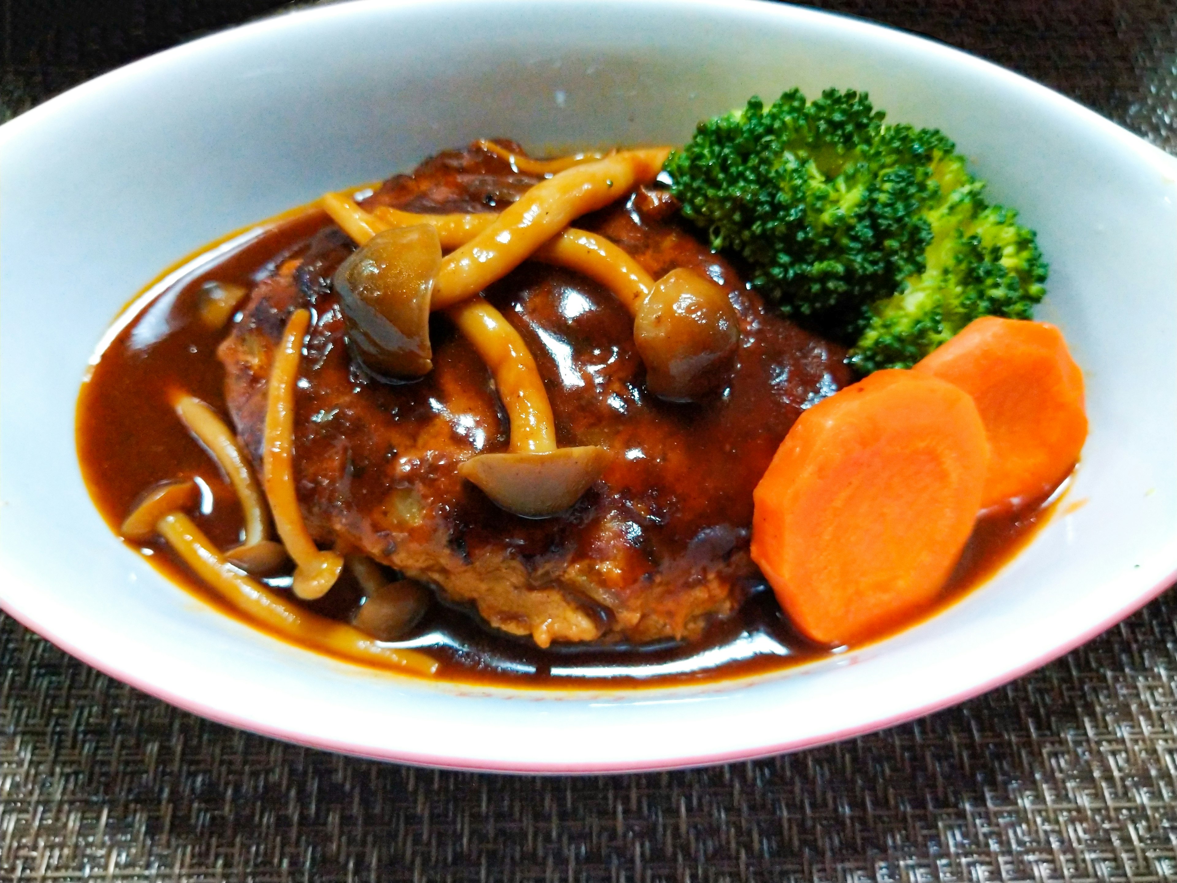 Delicious hamburger steak served with broccoli and carrots