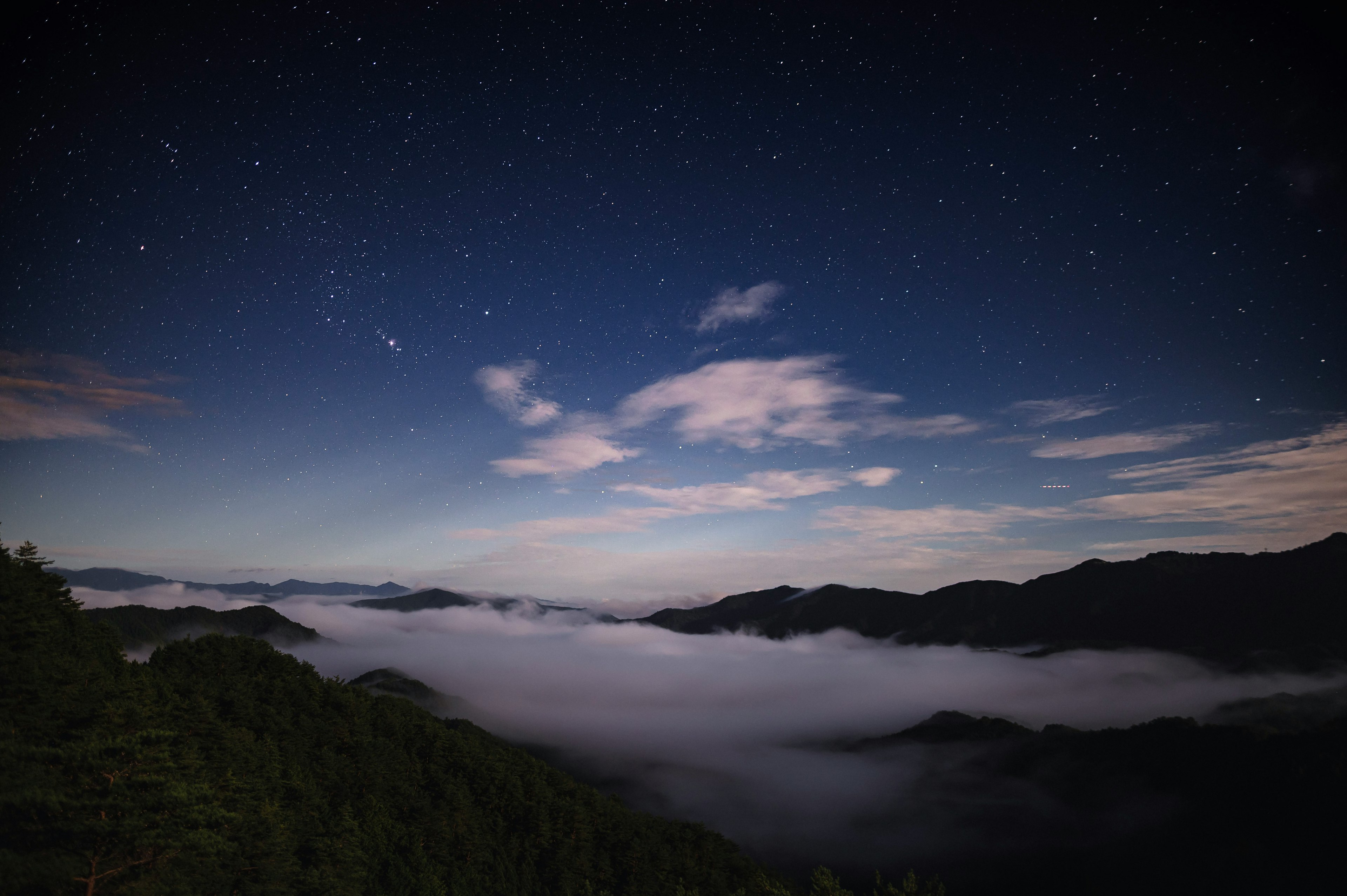 Bellissimo scenario notturno con cielo stellato e mare di nuvole