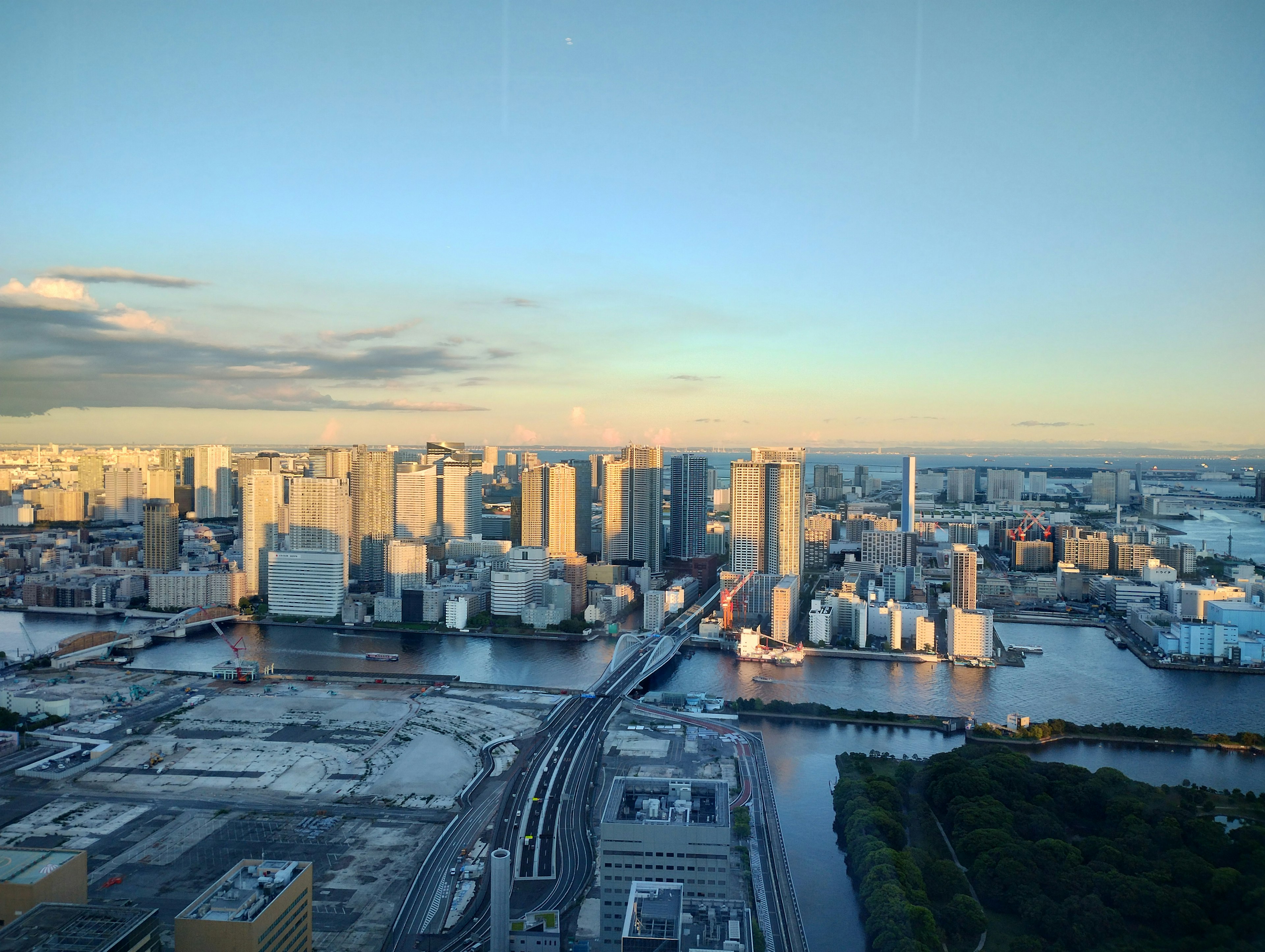 Pemandangan panorama gedung pencakar langit Tokyo dan sungai saat senja dengan langit tenang