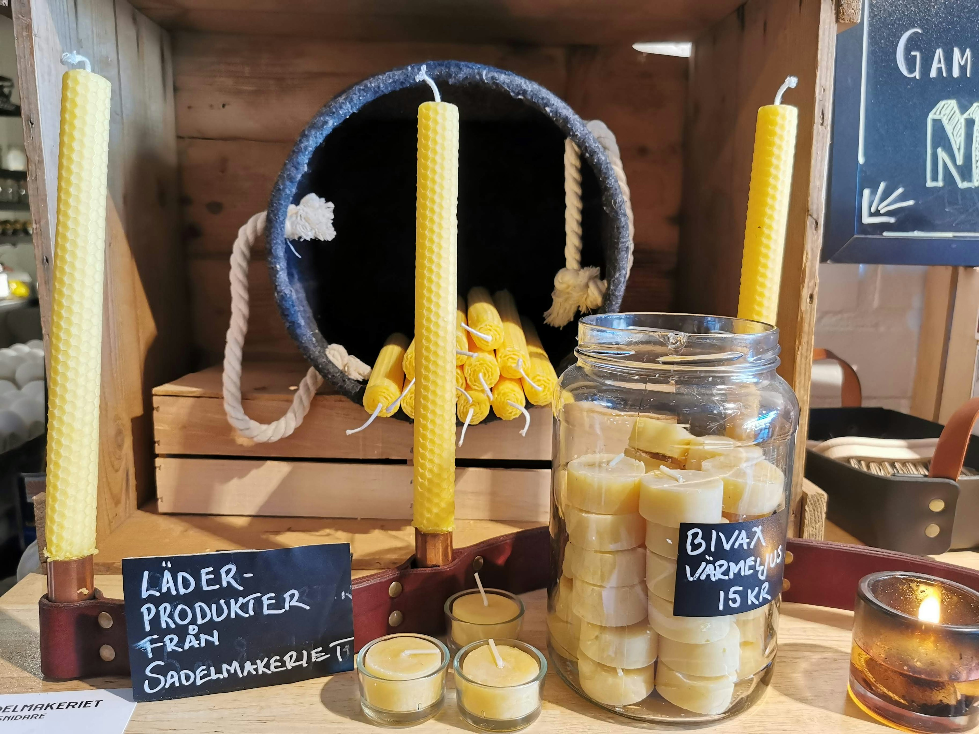 Display featuring honey-colored candles and a jar of small wax candles