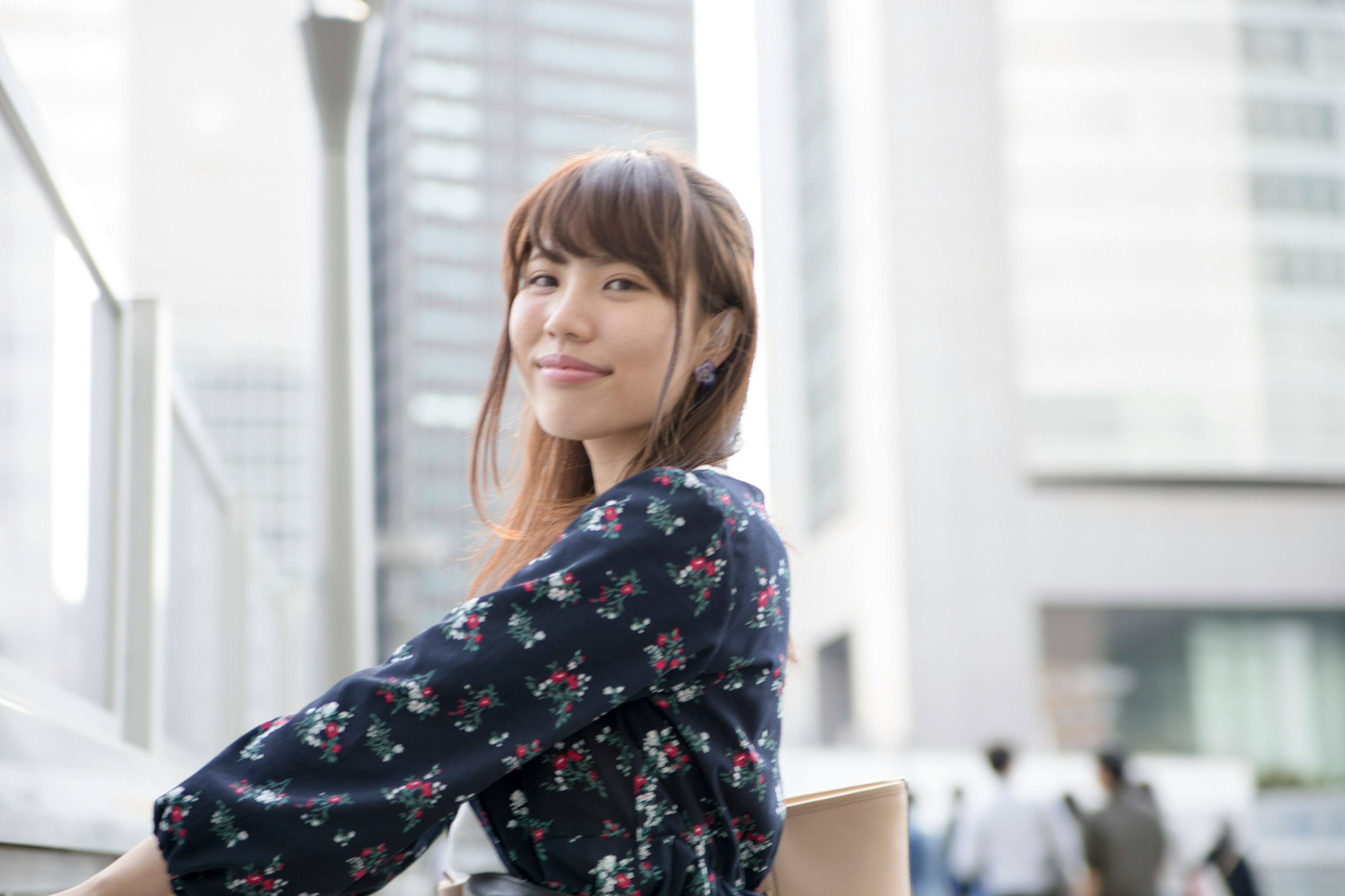 Portrait of a smiling woman with a cityscape background