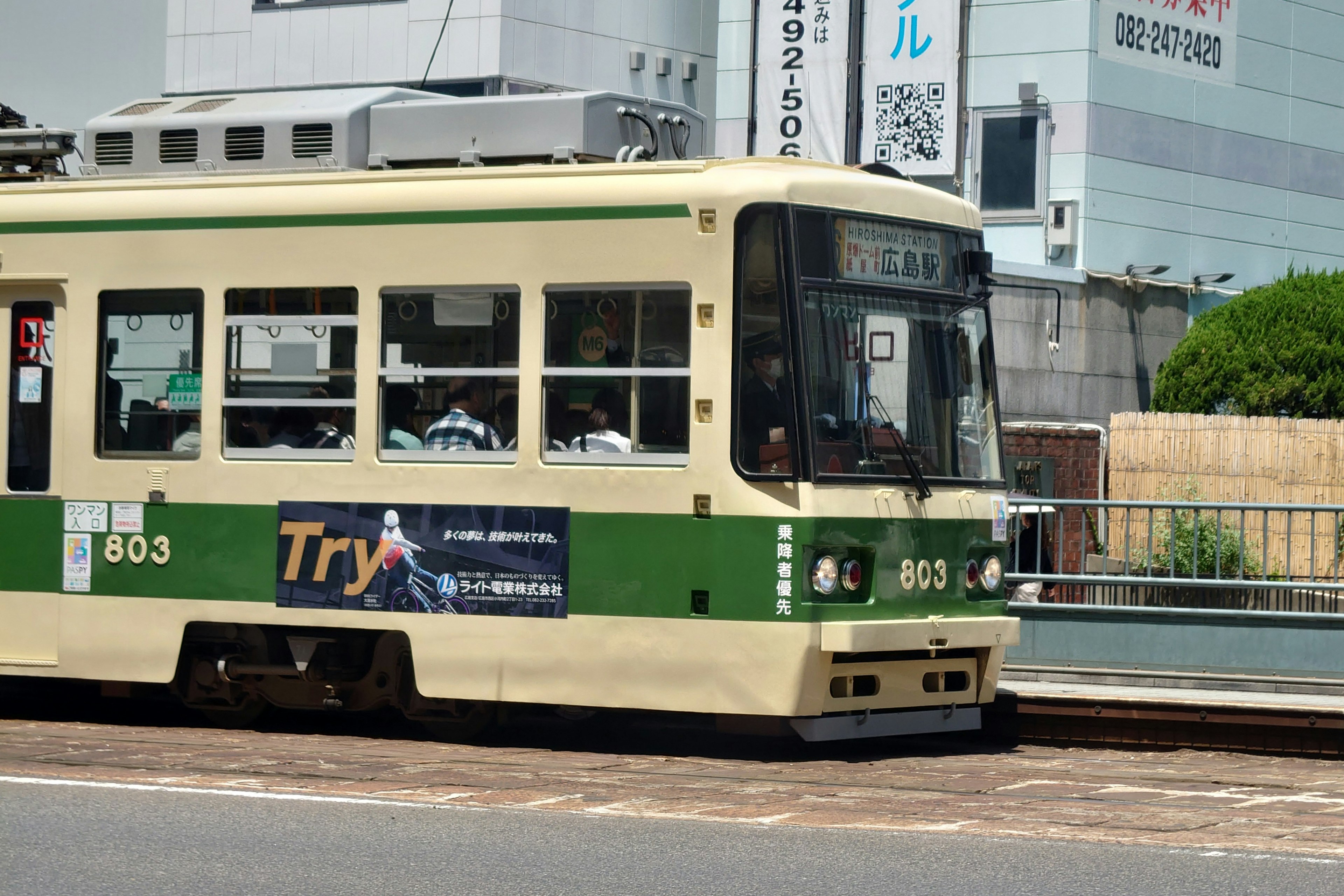 Un tram verde e crema fermo a una fermata