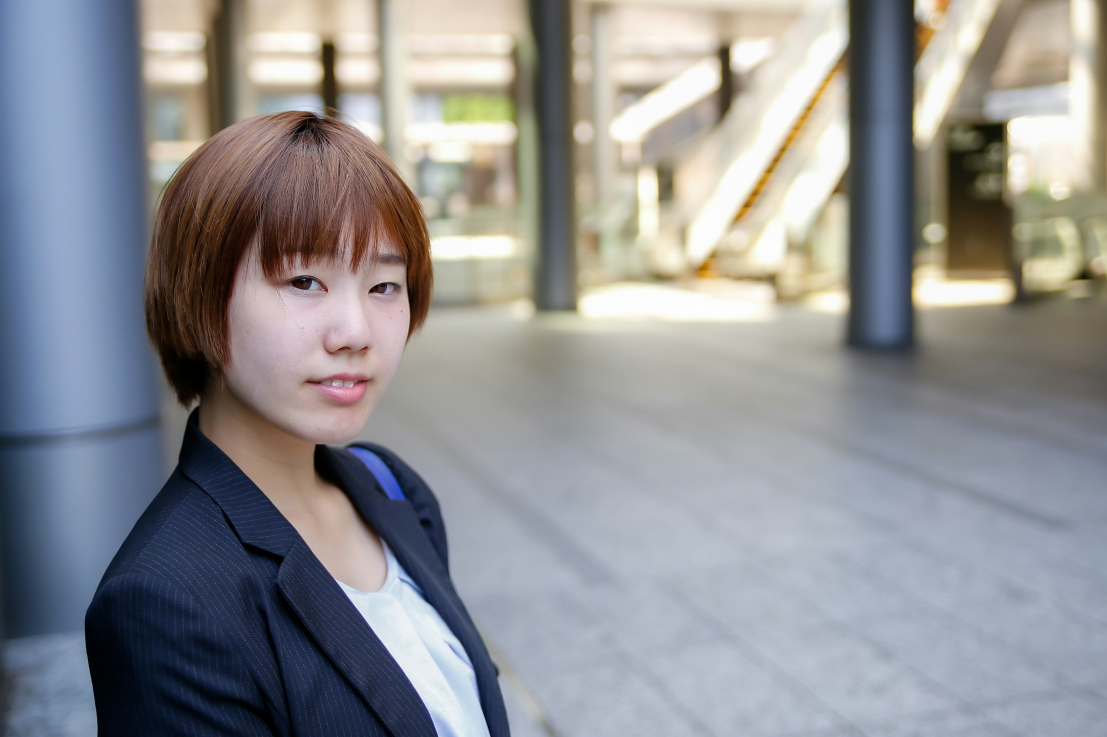 Young woman in business suit with modern building in background