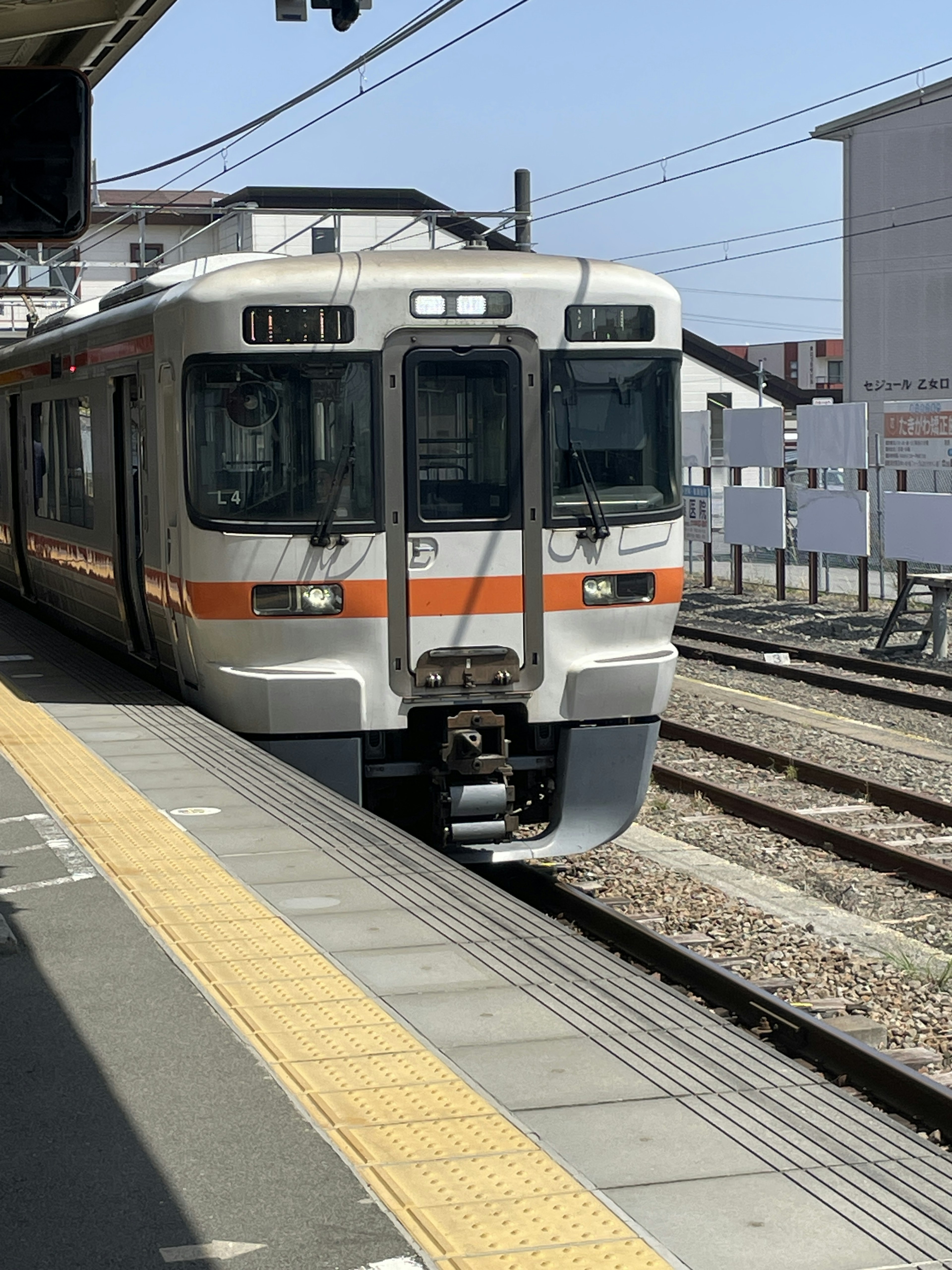 Train arriving at a station with visible tracks and platform